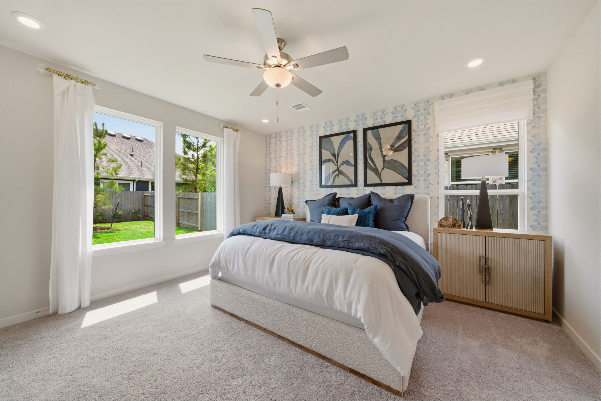 A bedroom with a large bed and a fan.