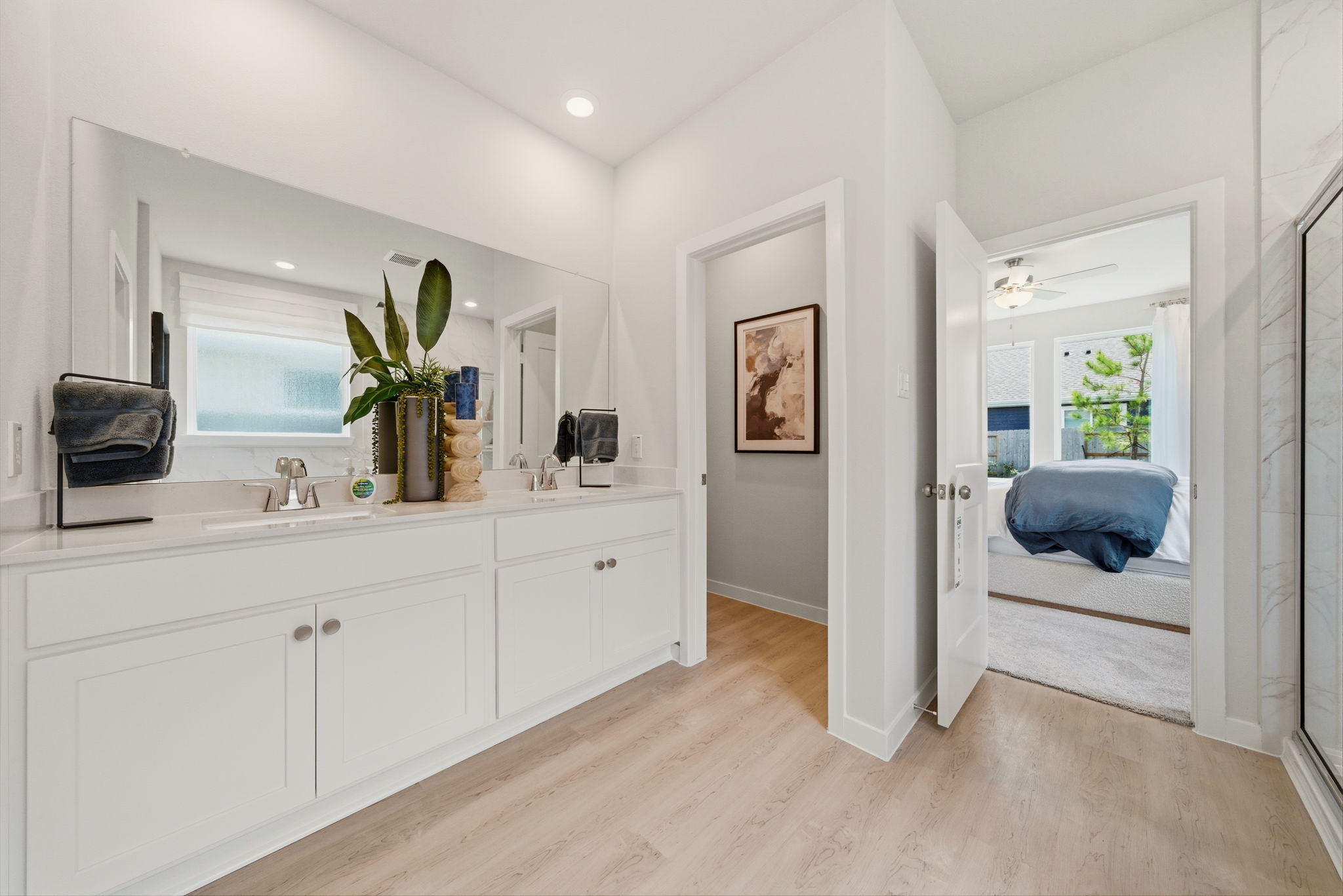 A bathroom with white cabinets.