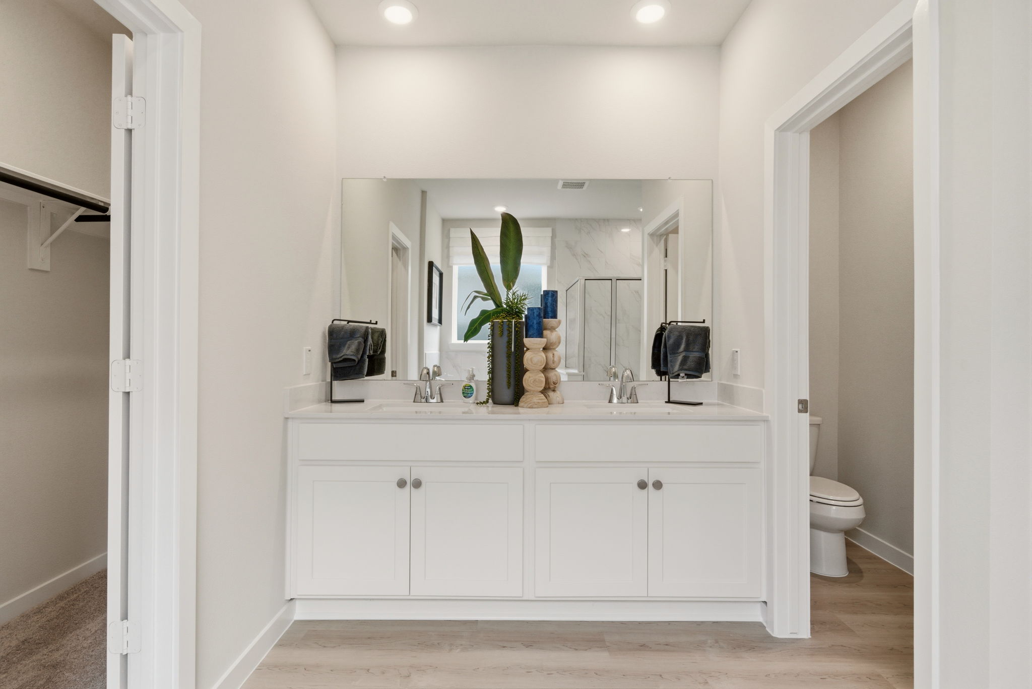 A bathroom with white cabinets.