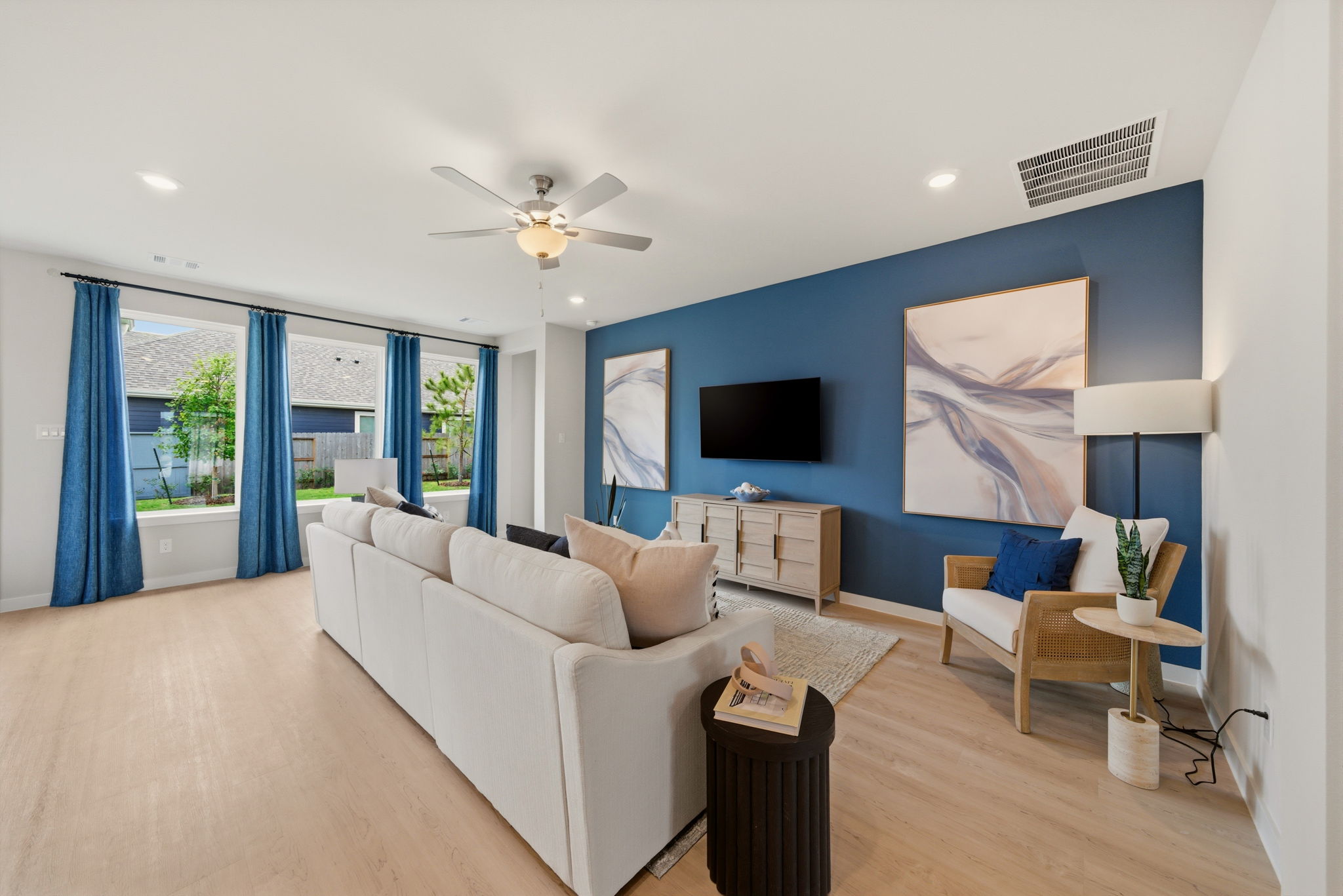 A living room with a white couch and a blue wall.