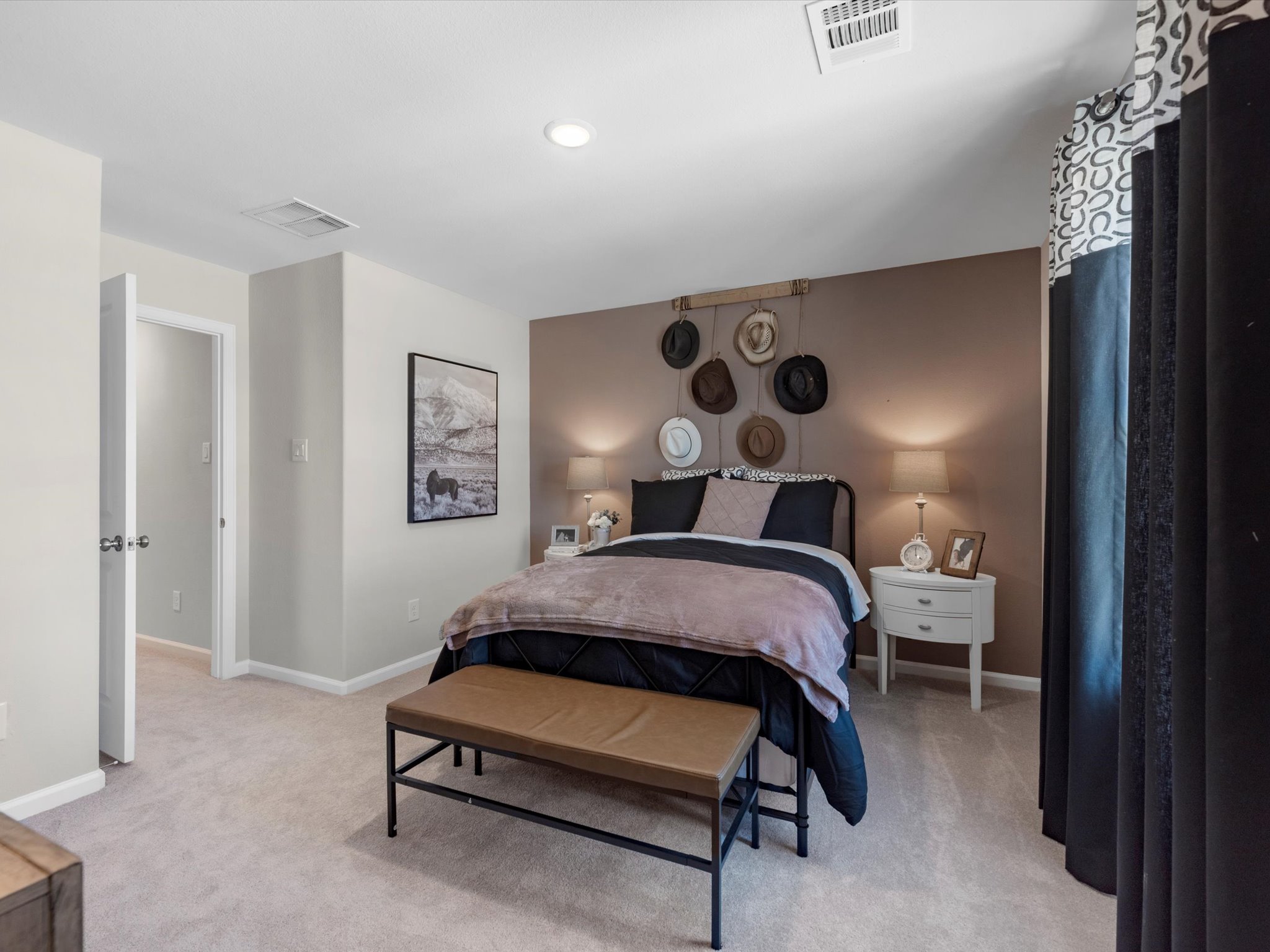 A bedroom with a bed and a bench.