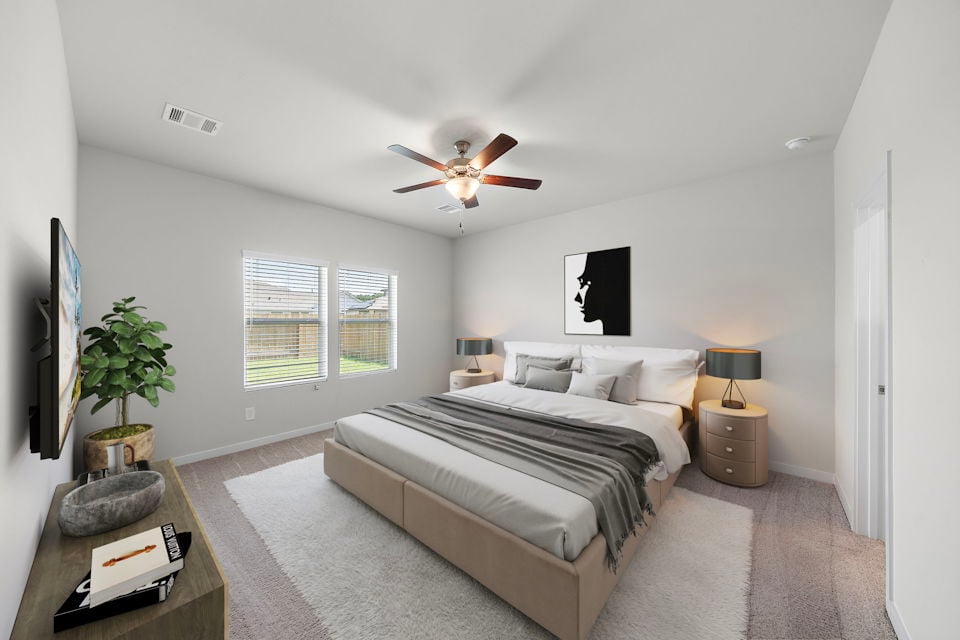 A bedroom with a bed and a fan.