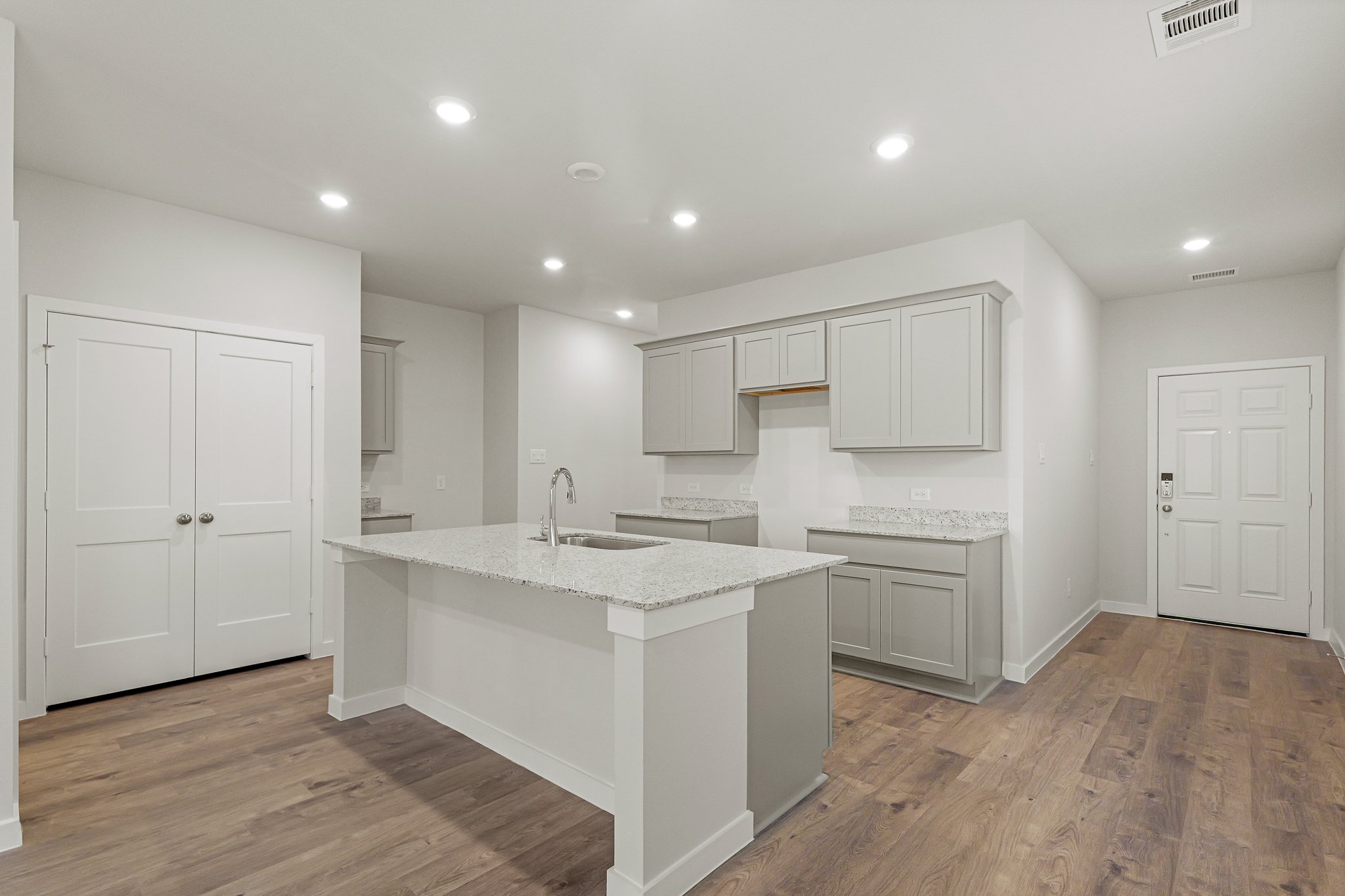 A kitchen with white cabinets.