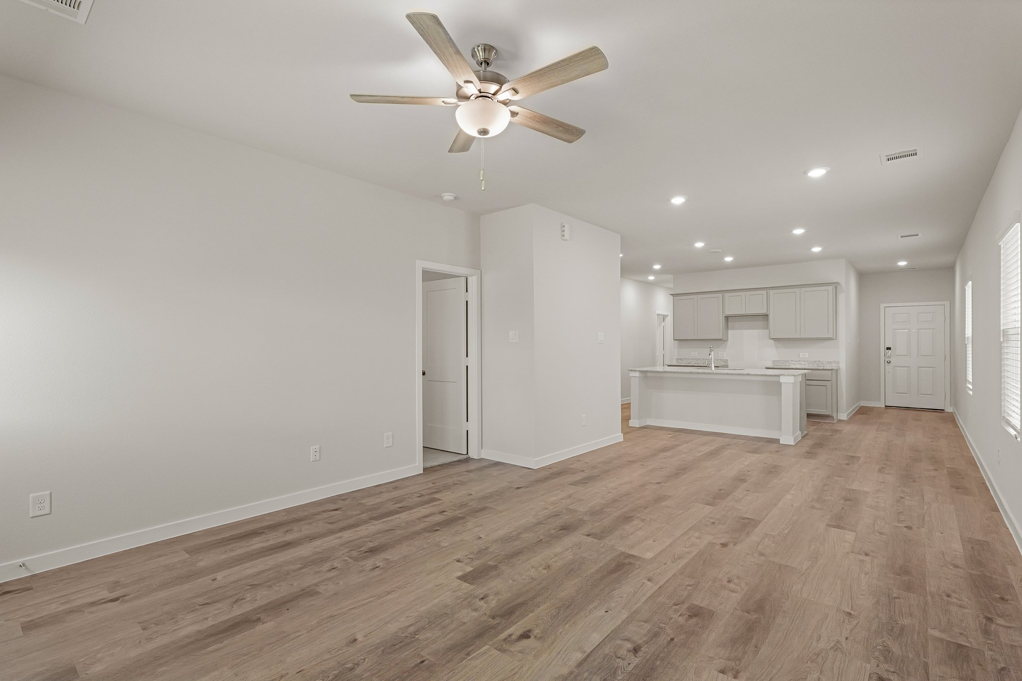A room with a wood floor and a ceiling fan.
