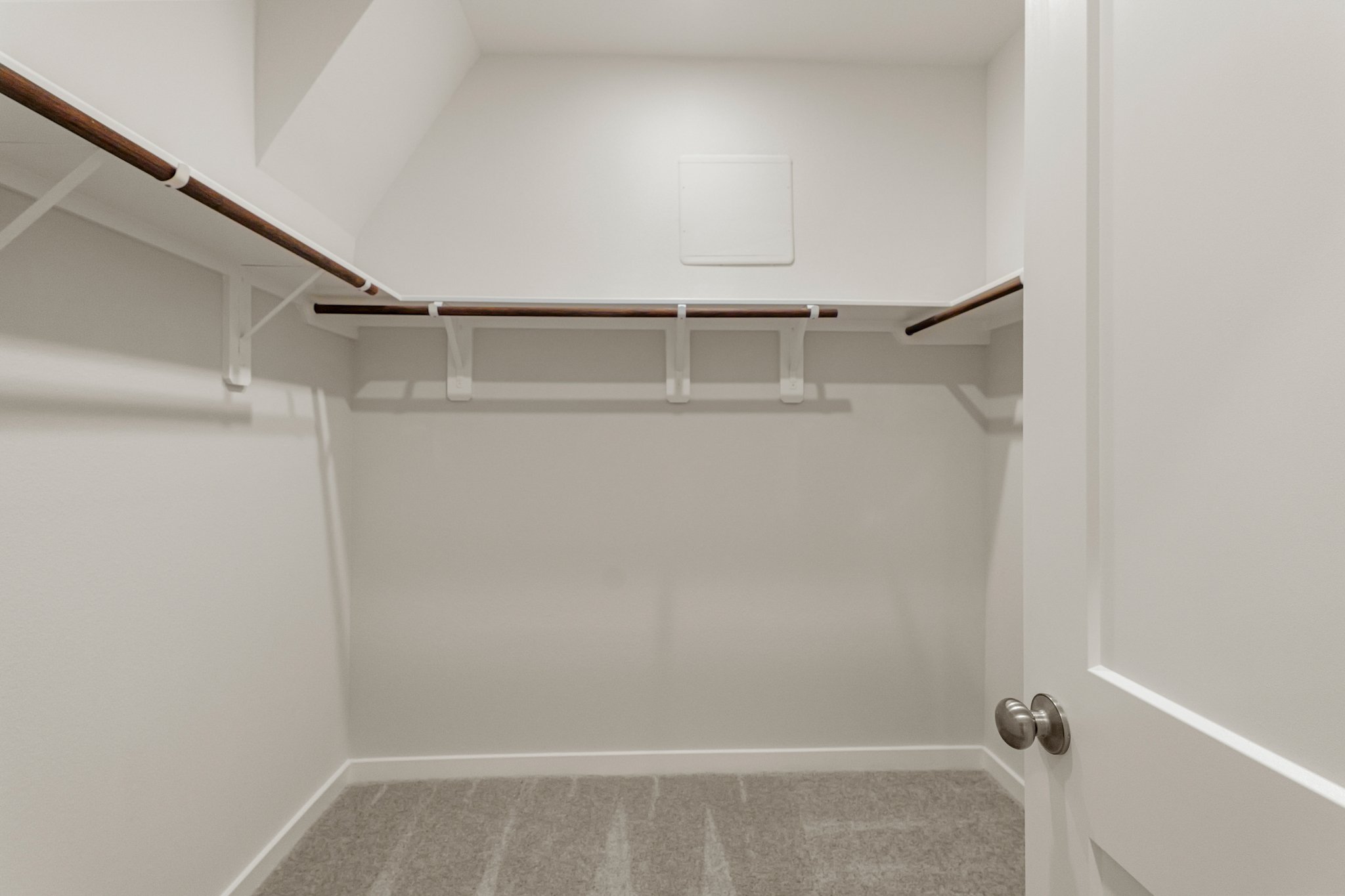 A white room with a white door and a metal railing.