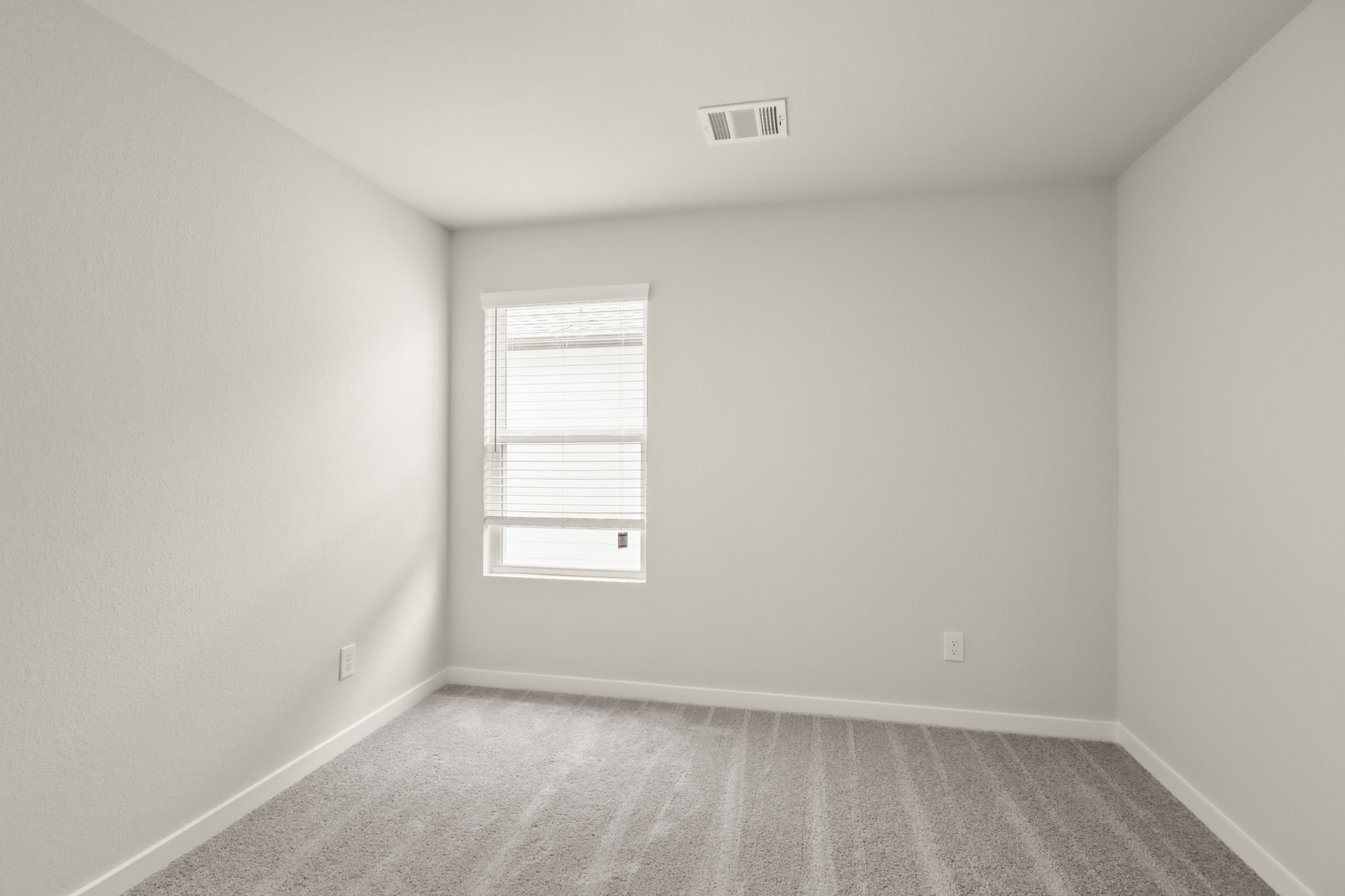 A room with a window and a carpet.