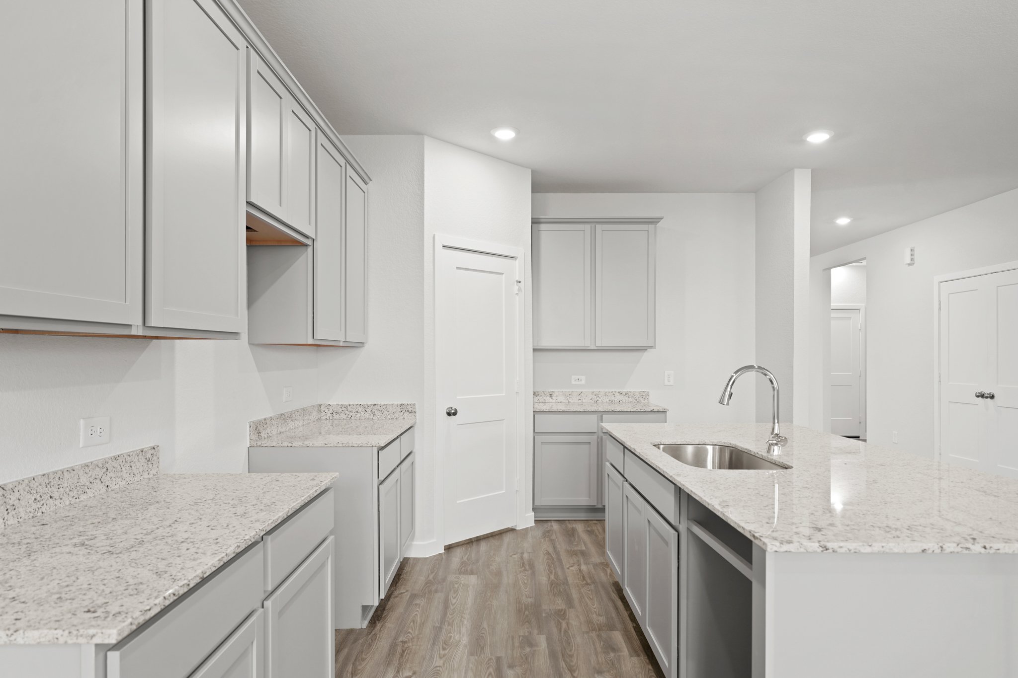 A kitchen with white cabinets.