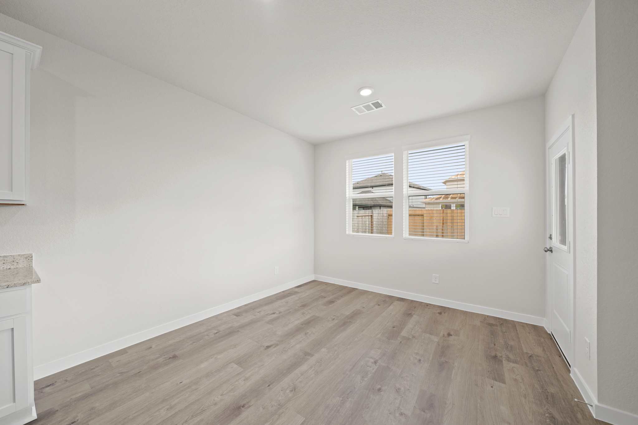 A room with a wood floor and a window.