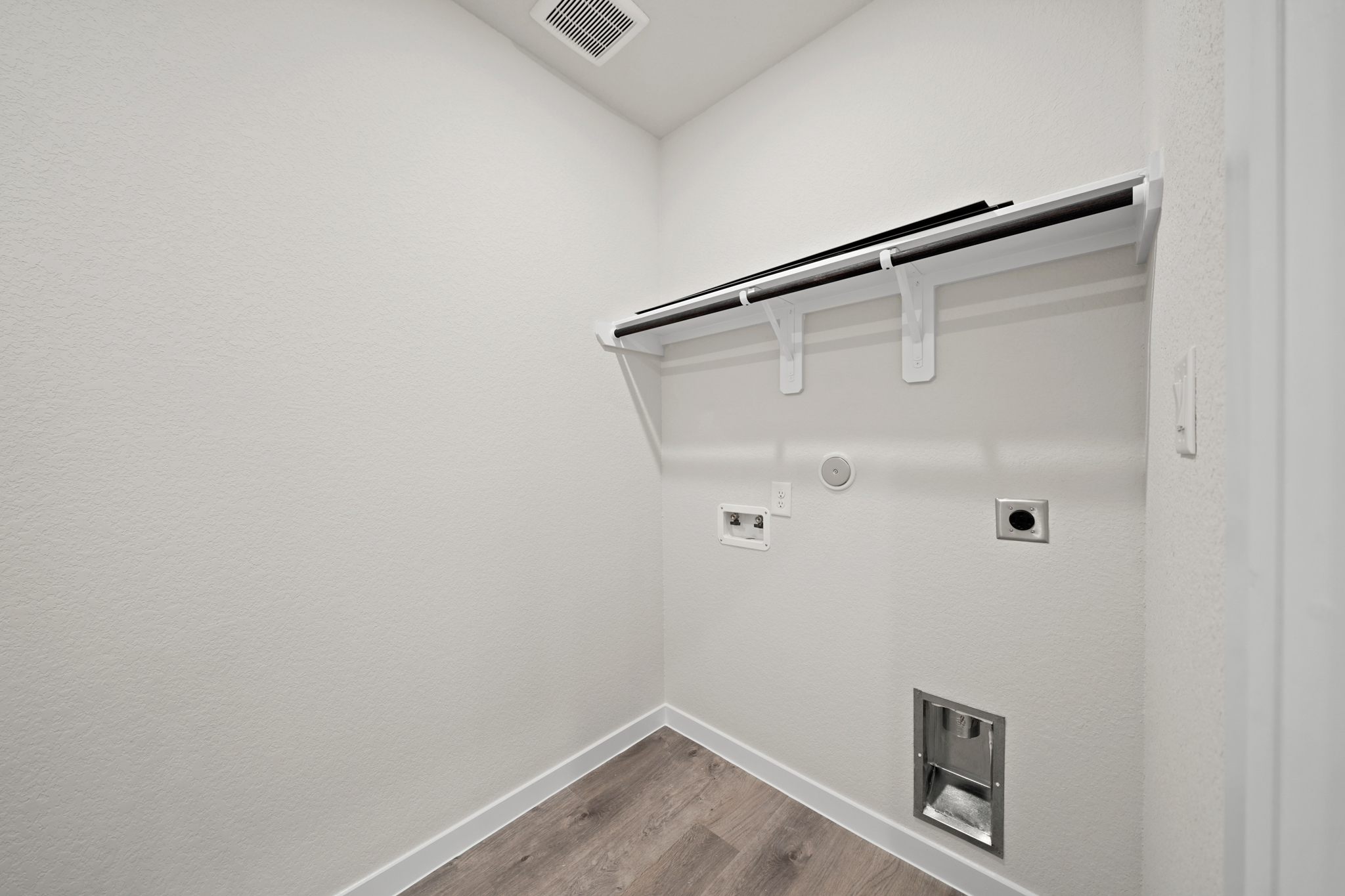 A white wall with a metal bar.