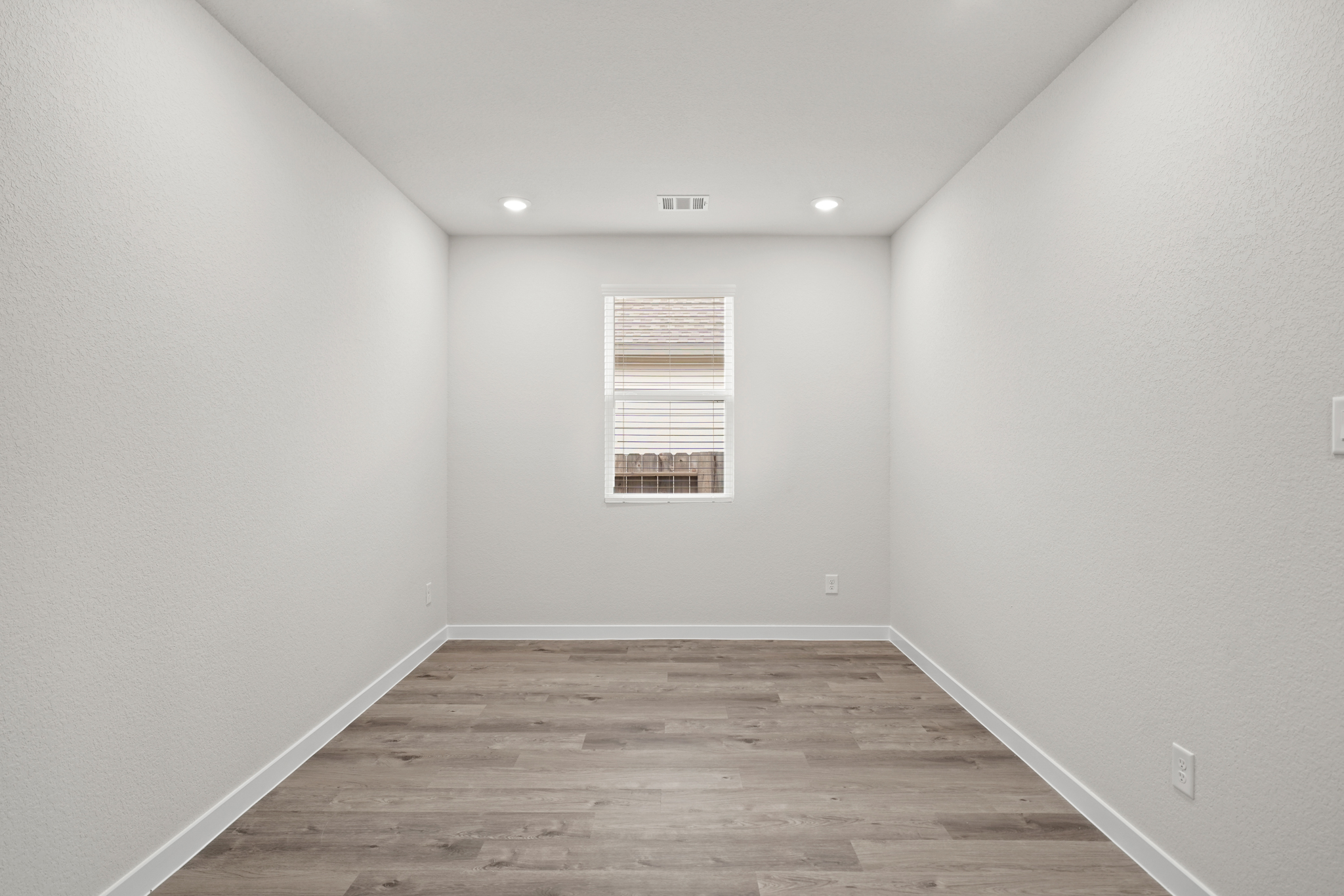 A room with a wood floor and a window.