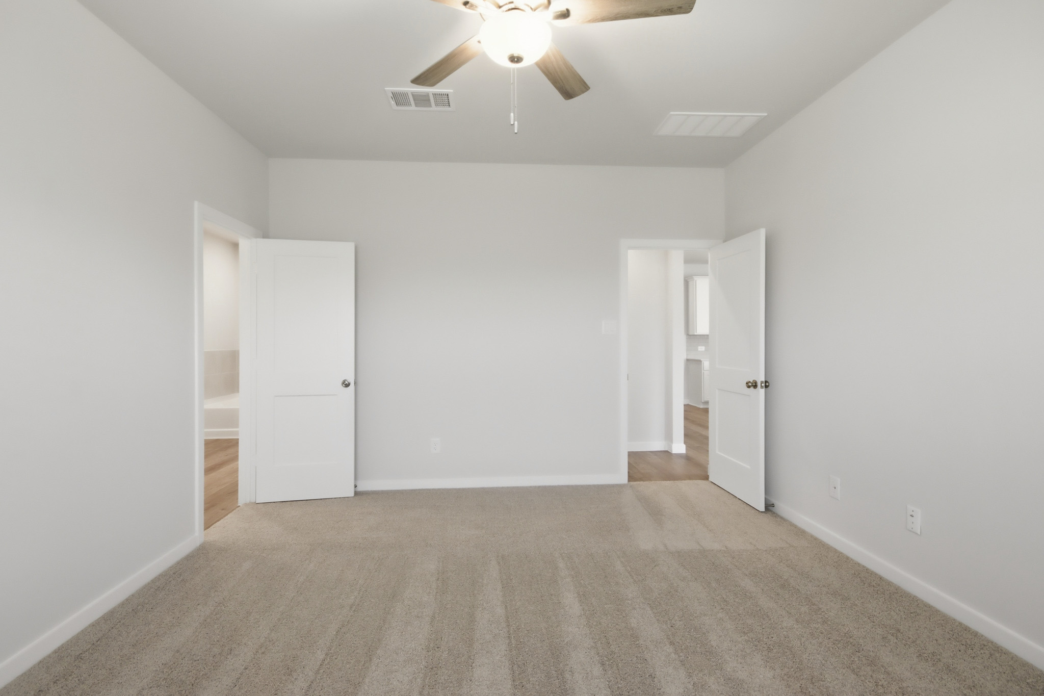 A room with white walls and a ceiling fan.