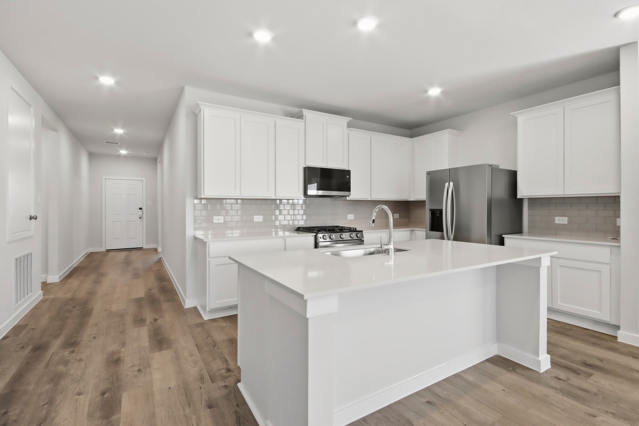 A kitchen with white cabinets.