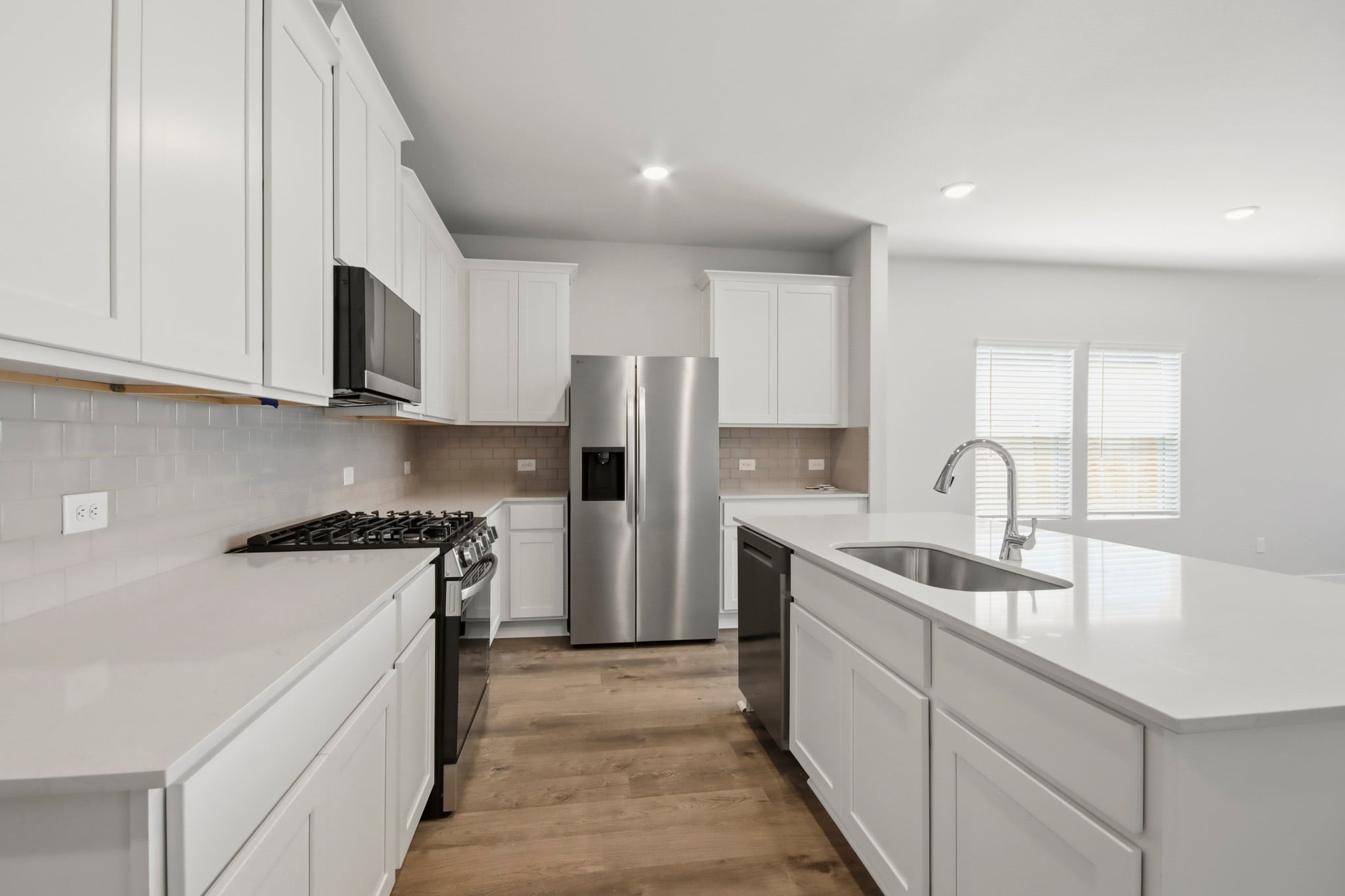 A kitchen with white cabinets.