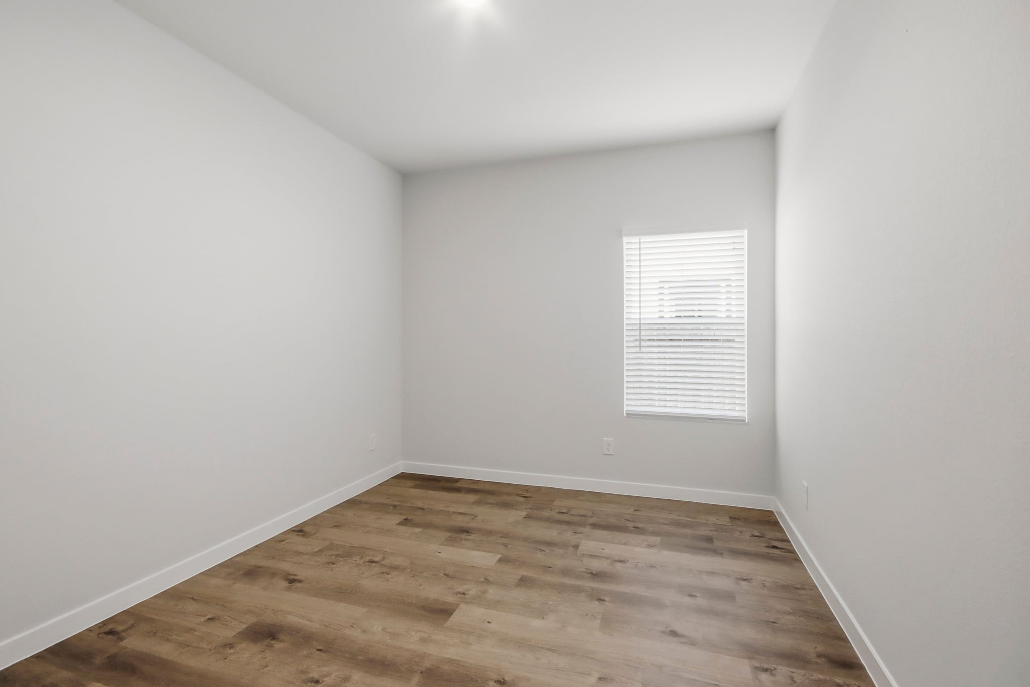 A room with a wood floor and white walls.