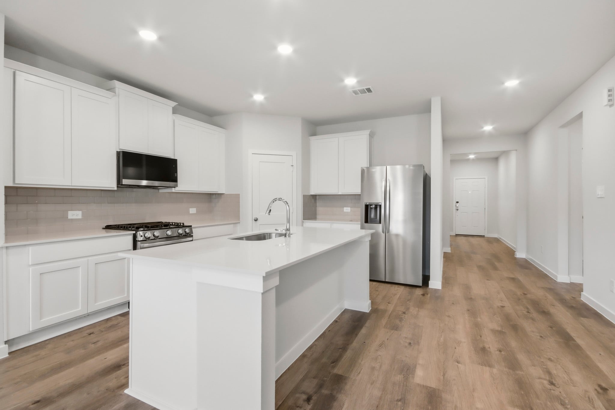 A kitchen with white cabinets.