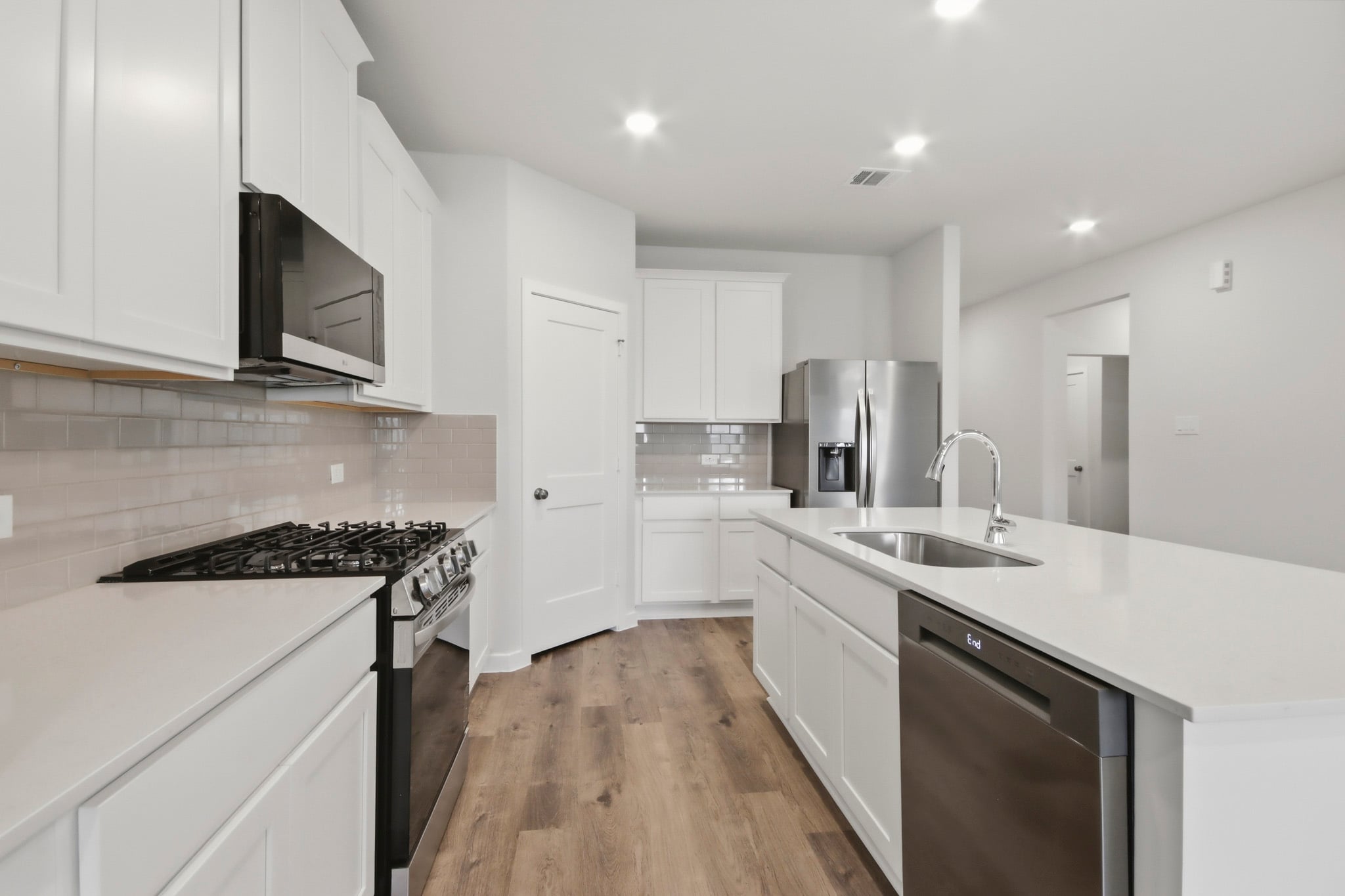 A kitchen with white cabinets.