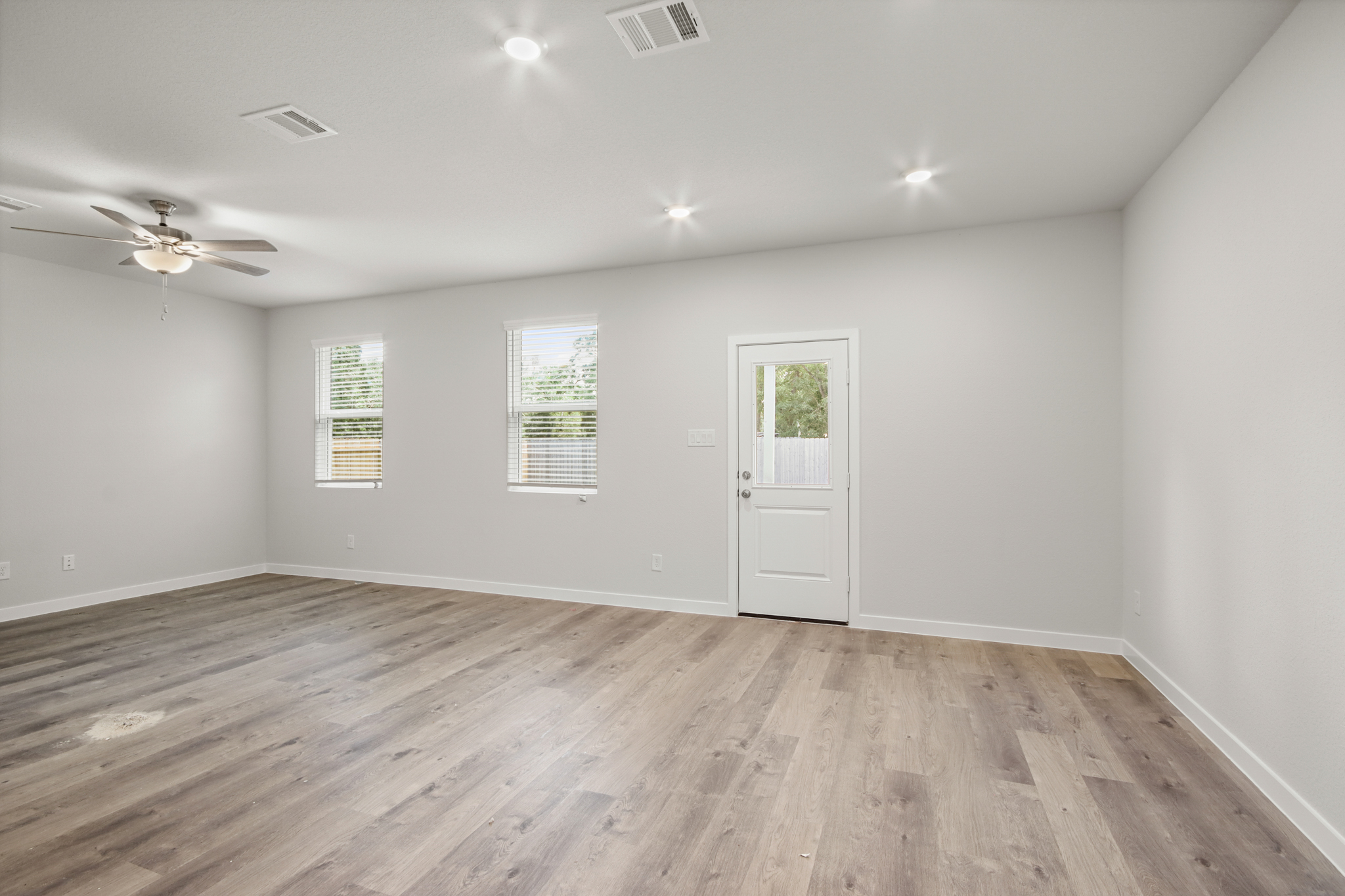 A room with a wood floor and a ceiling fan.