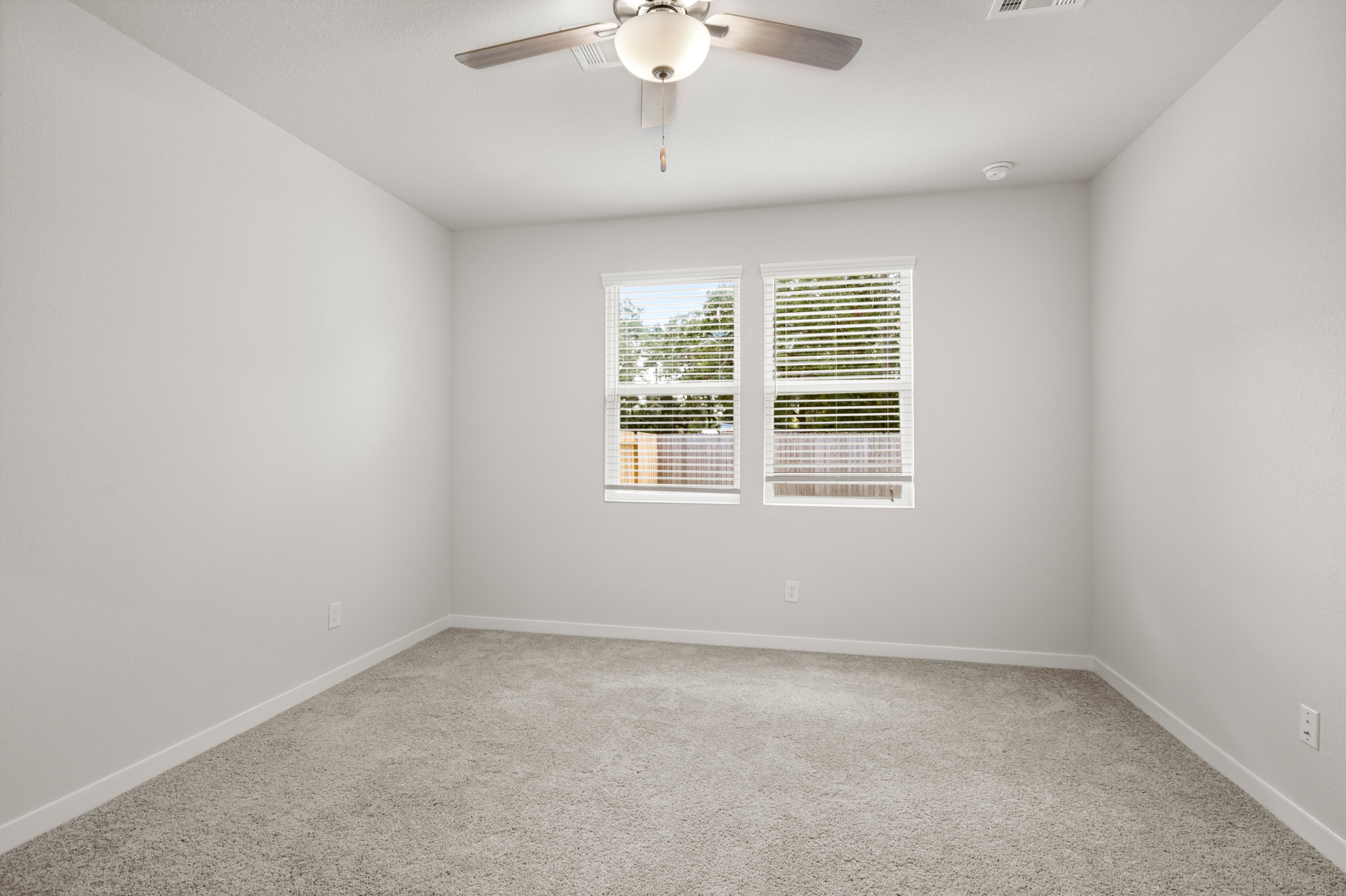 A room with a ceiling fan and a window.