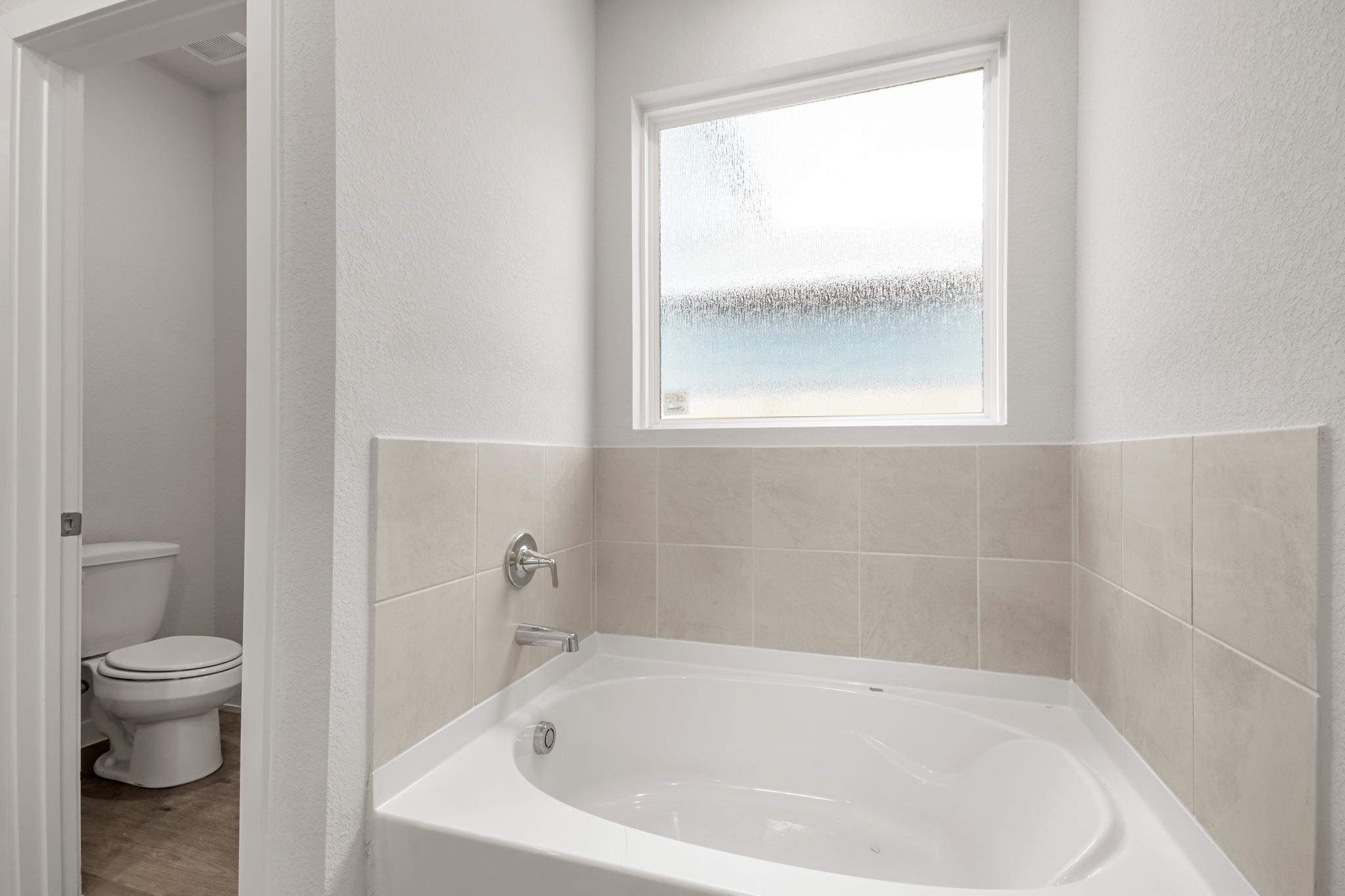 A bathroom with a tub and toilet.