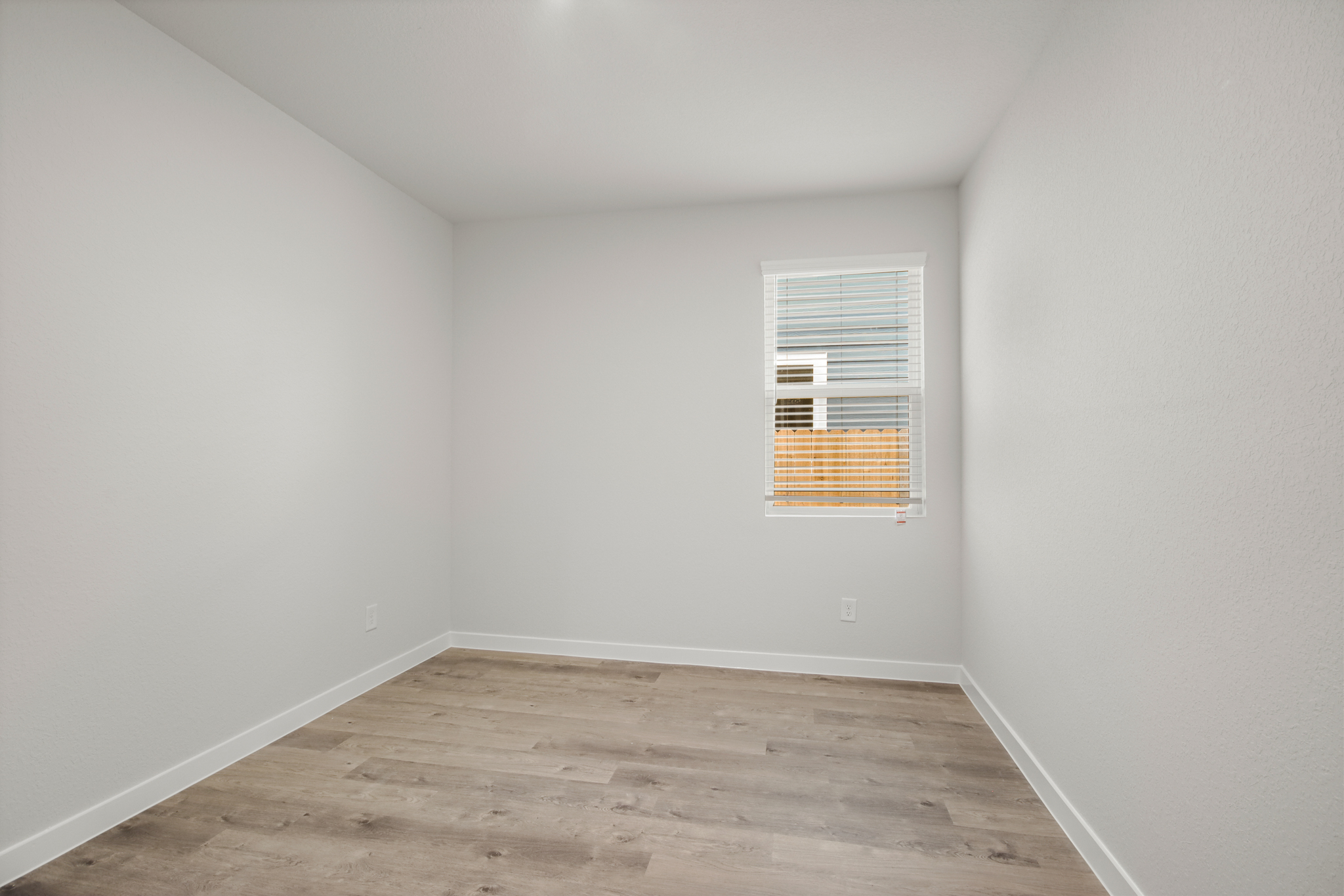 A room with a wood floor and a window.