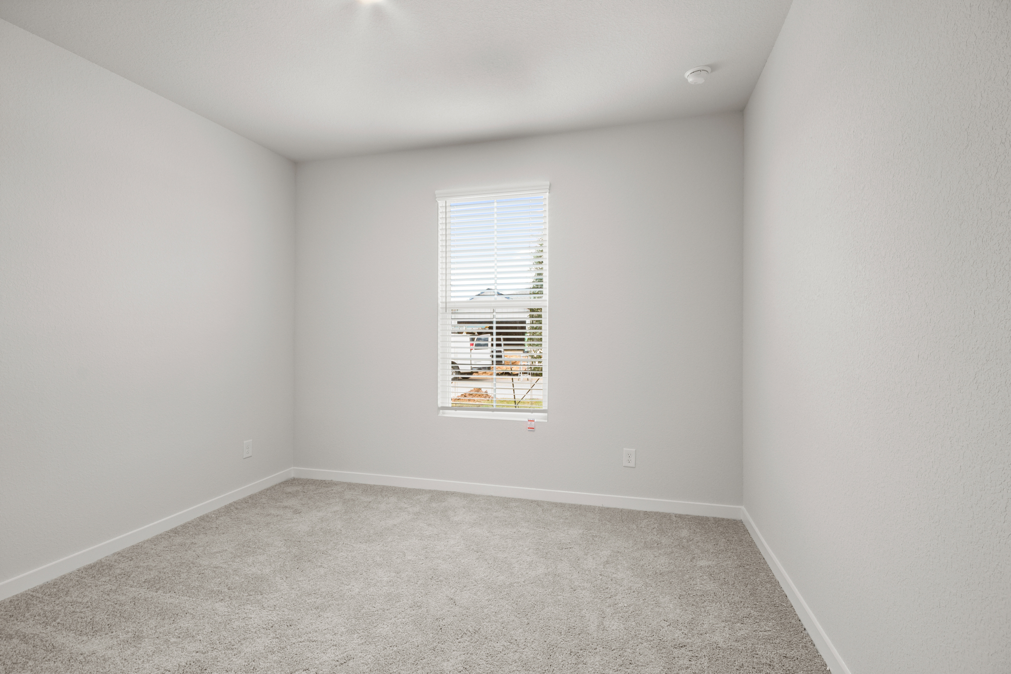 A room with a window and a carpet.