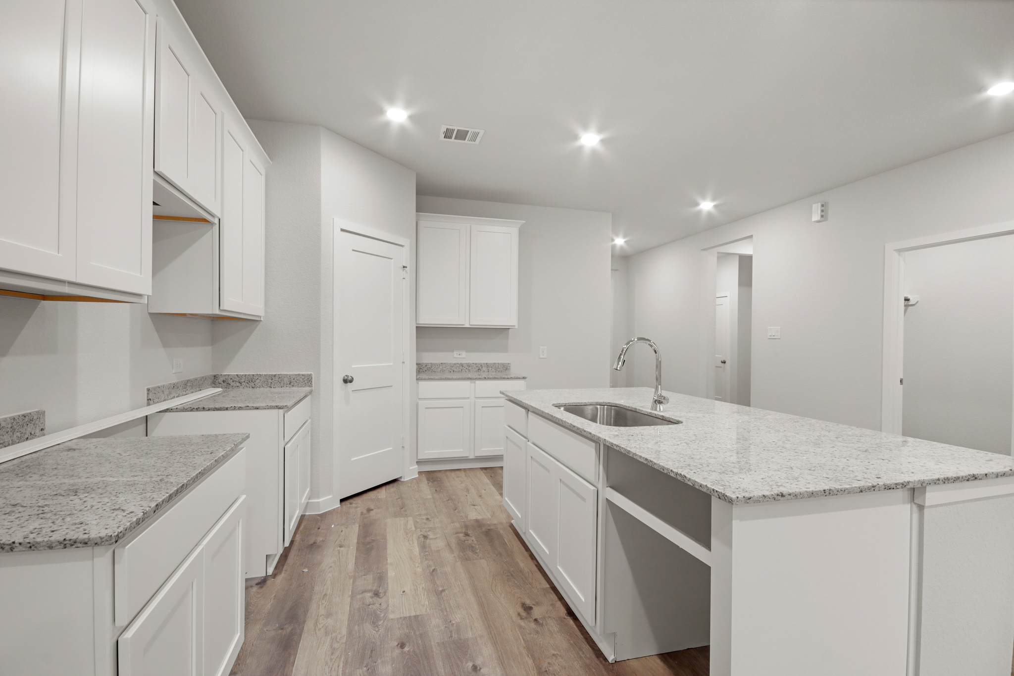 A kitchen with white cabinets.