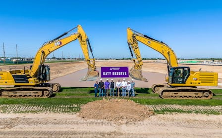 A group of people standing in front of a construction site.