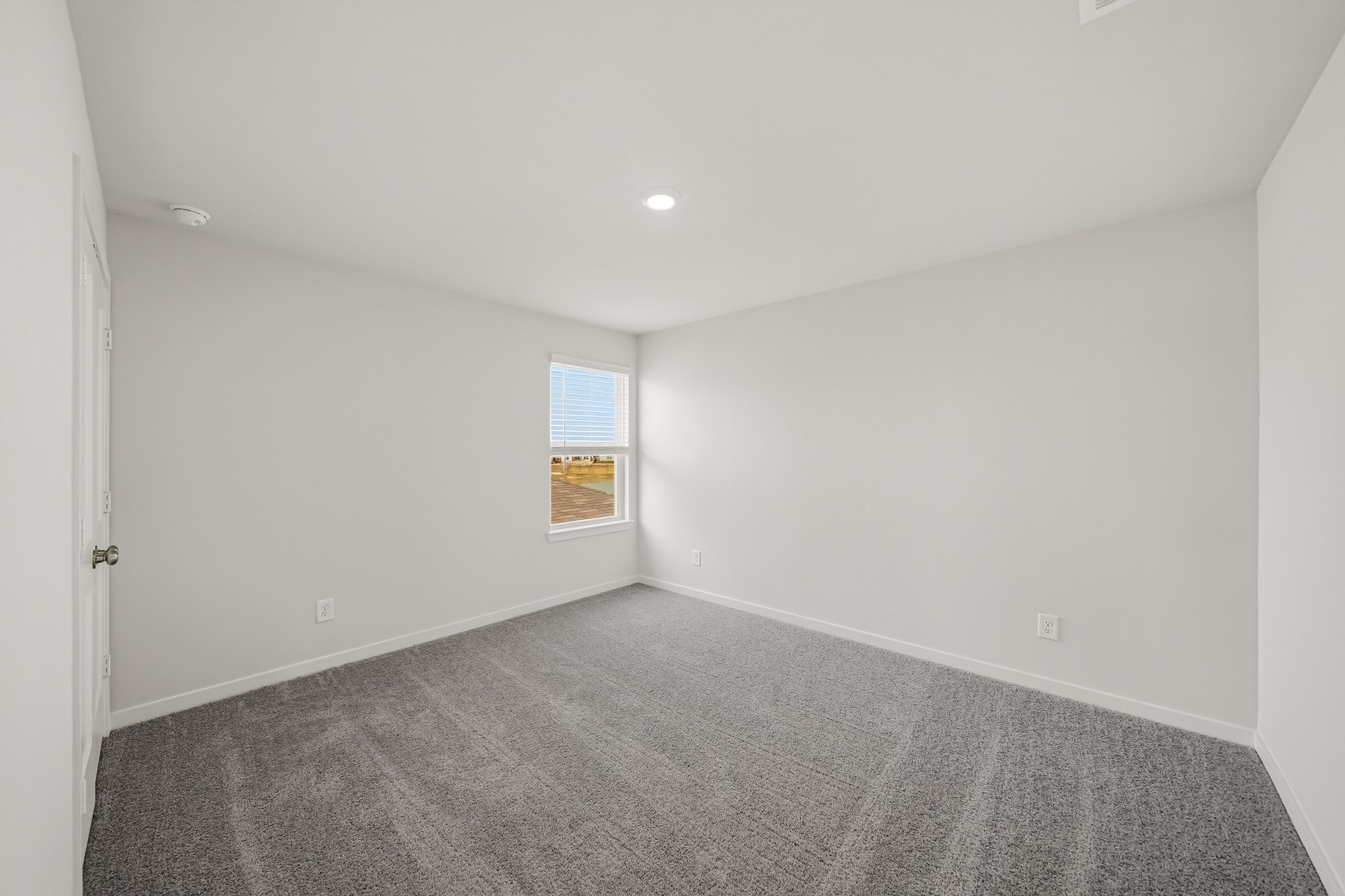 A room with a carpet and a window.