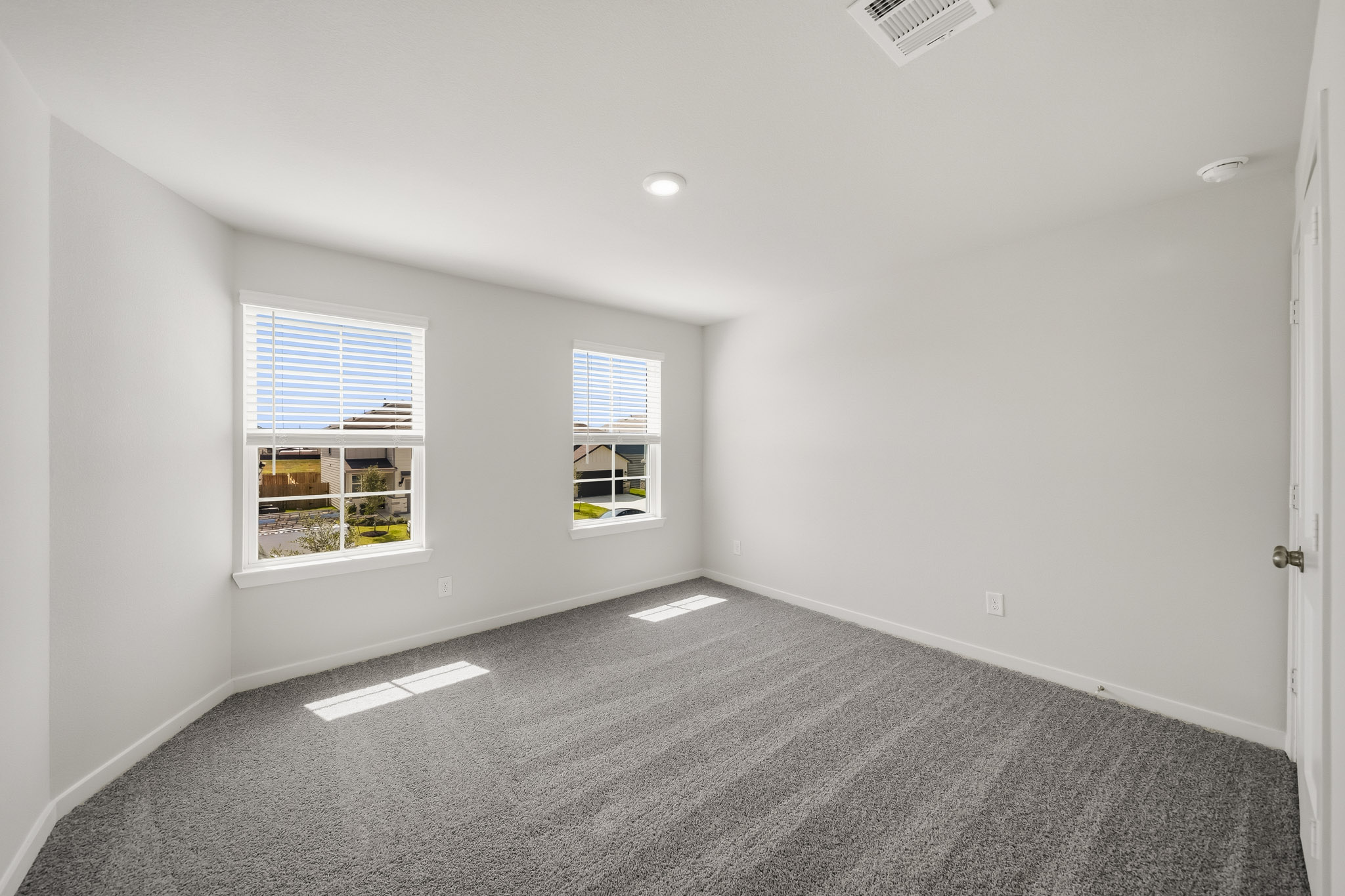 A room with windows and a carpet.
