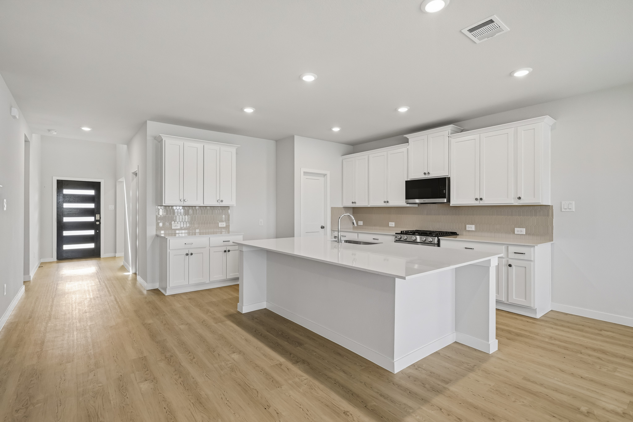 A kitchen with white cabinets.