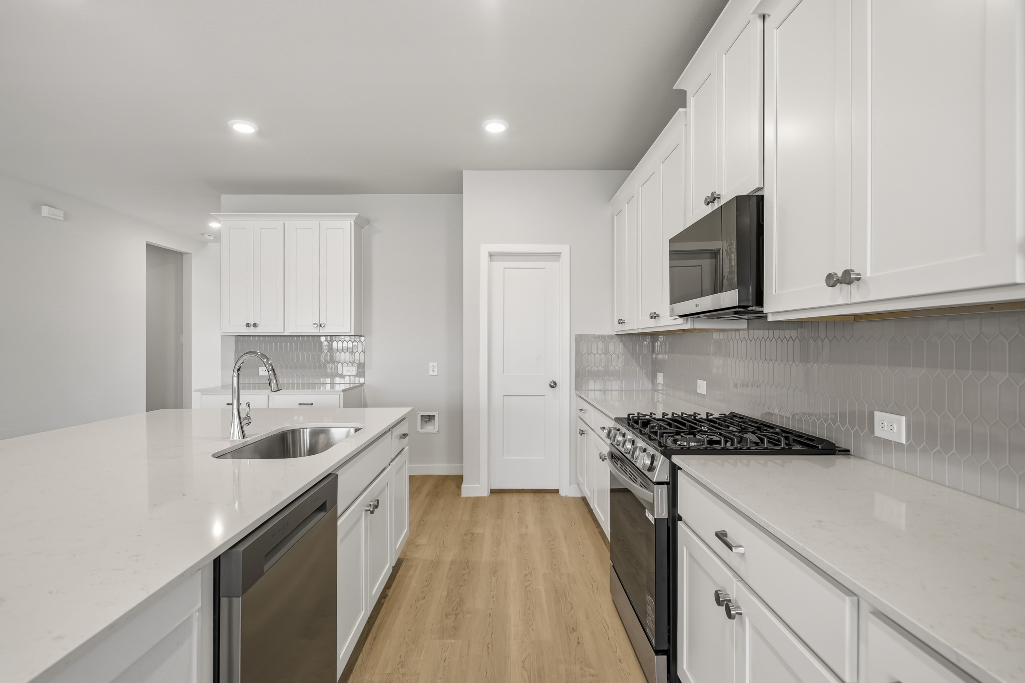 A kitchen with white cabinets.