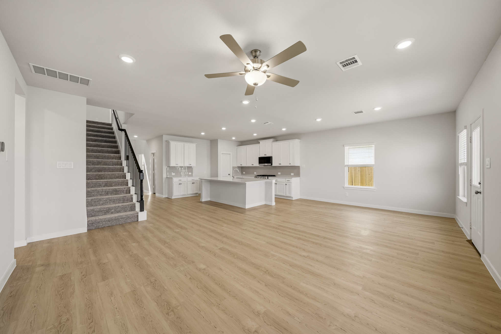 A large empty room with a wood floor and a wood floor.
