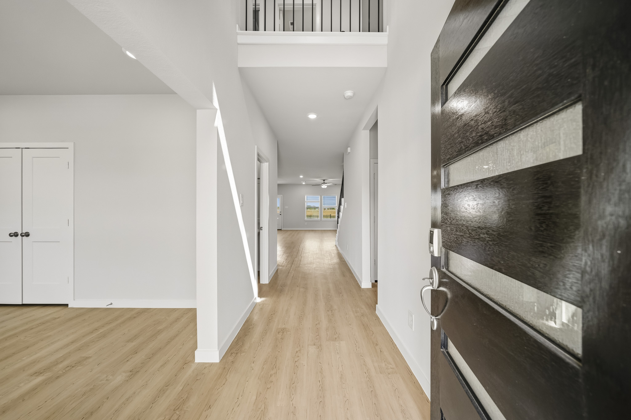 A hallway with white cabinets.