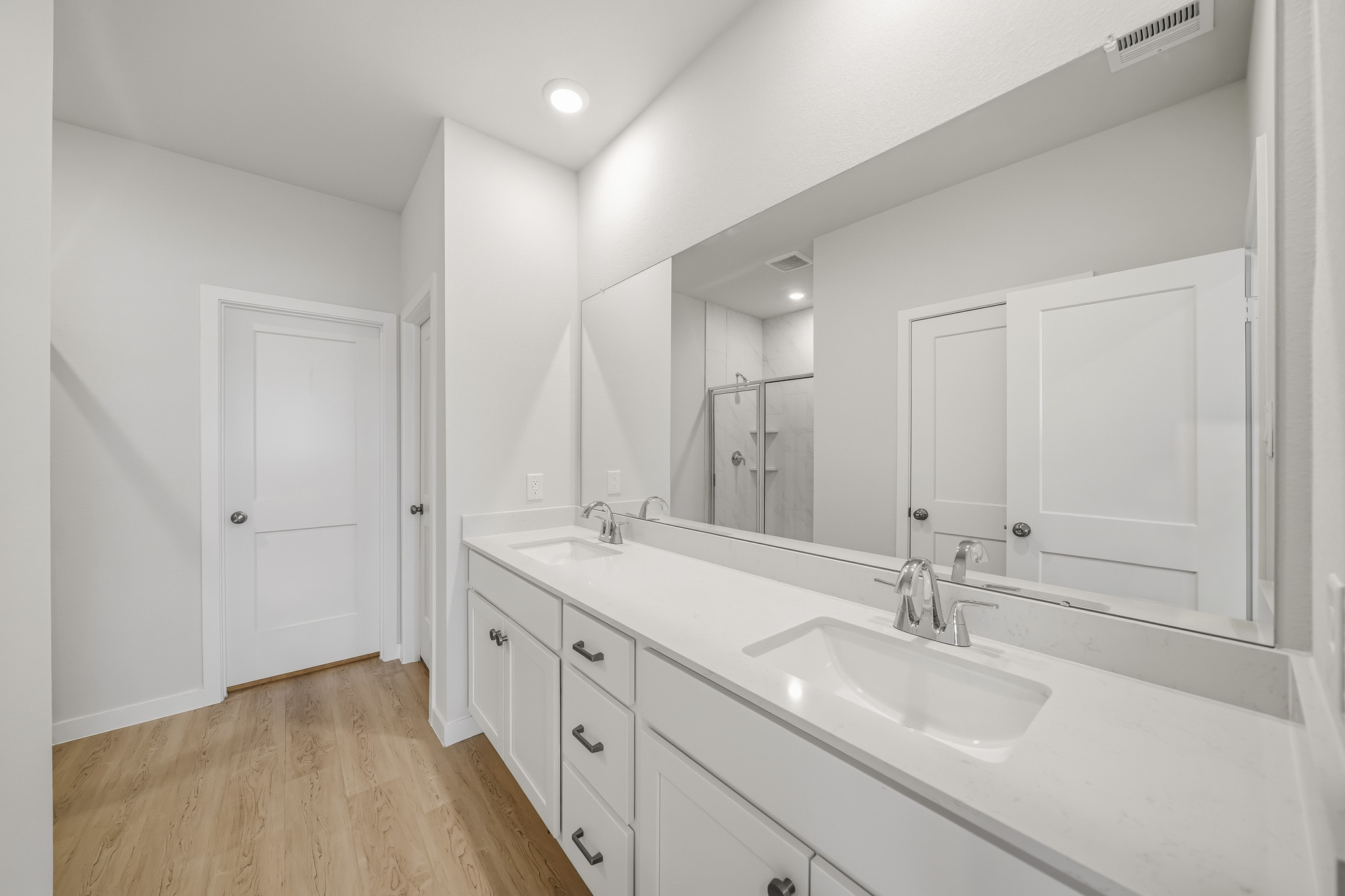 A bathroom with white cabinets.