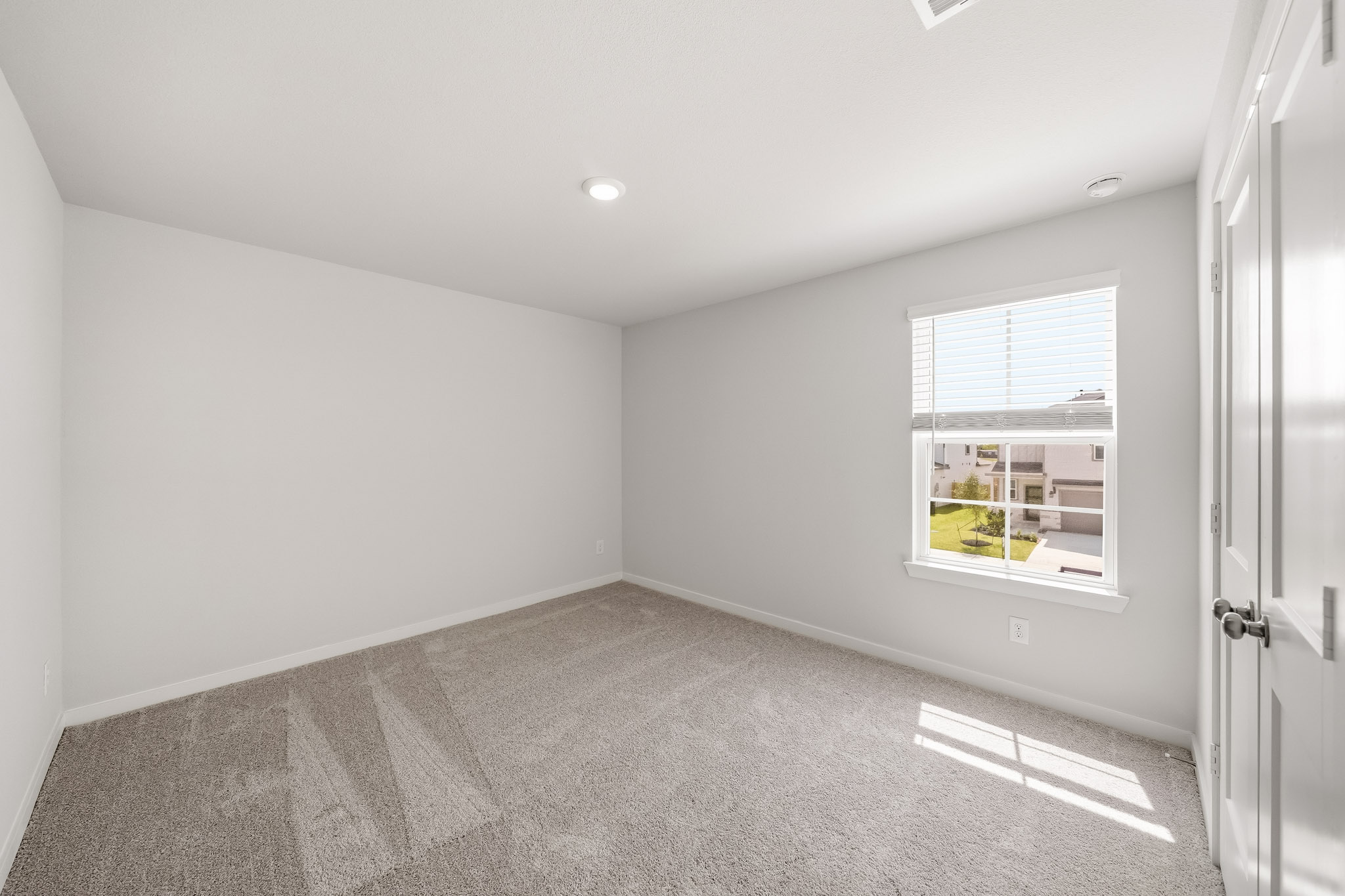 A room with a window and a carpet.