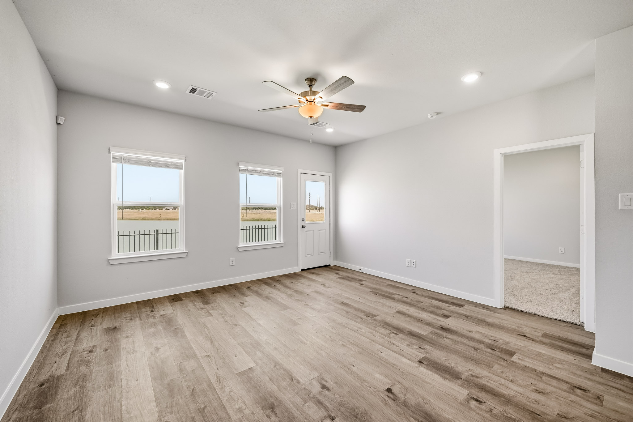 A room with a wood floor and a ceiling fan.