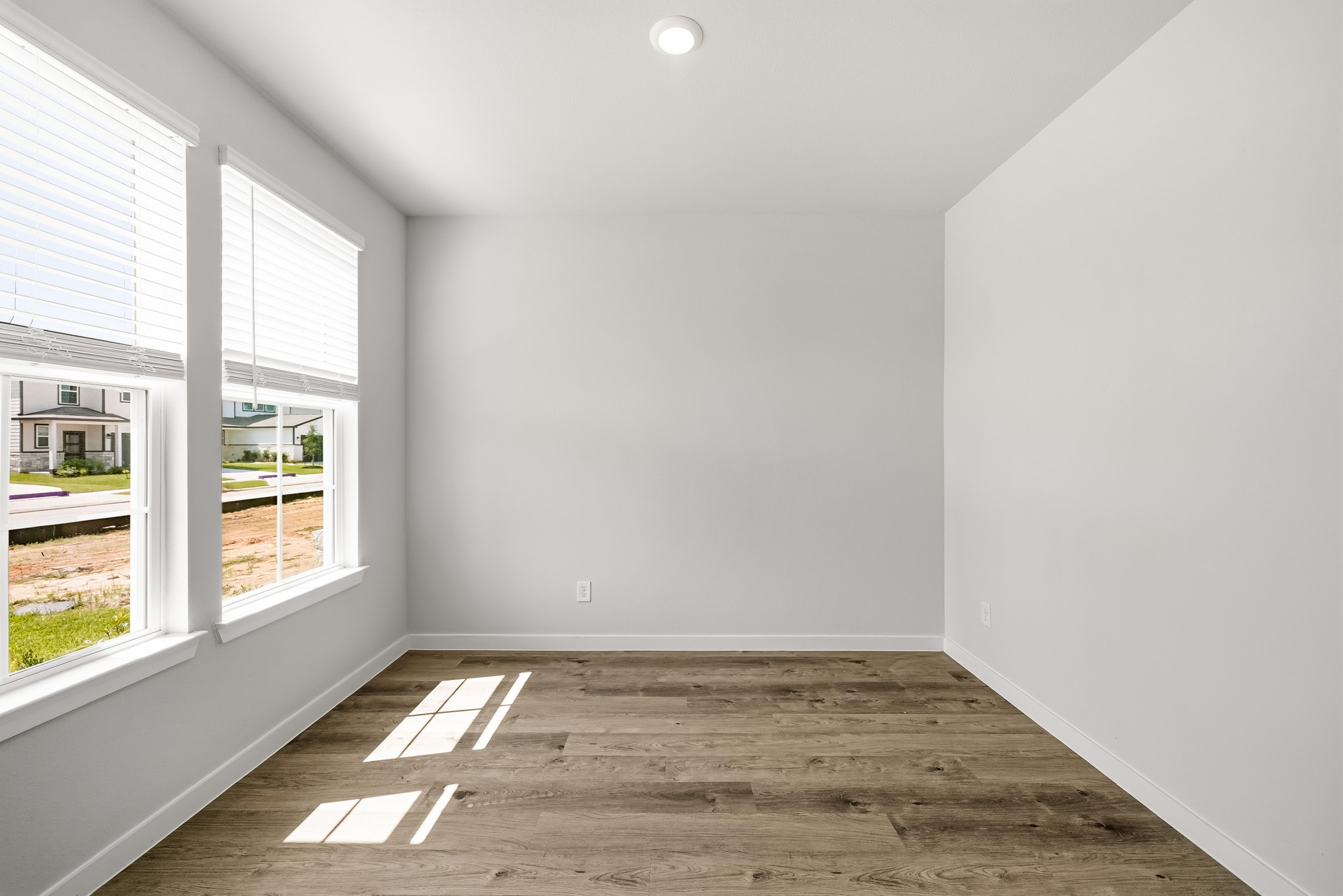 A room with a wood floor and windows.