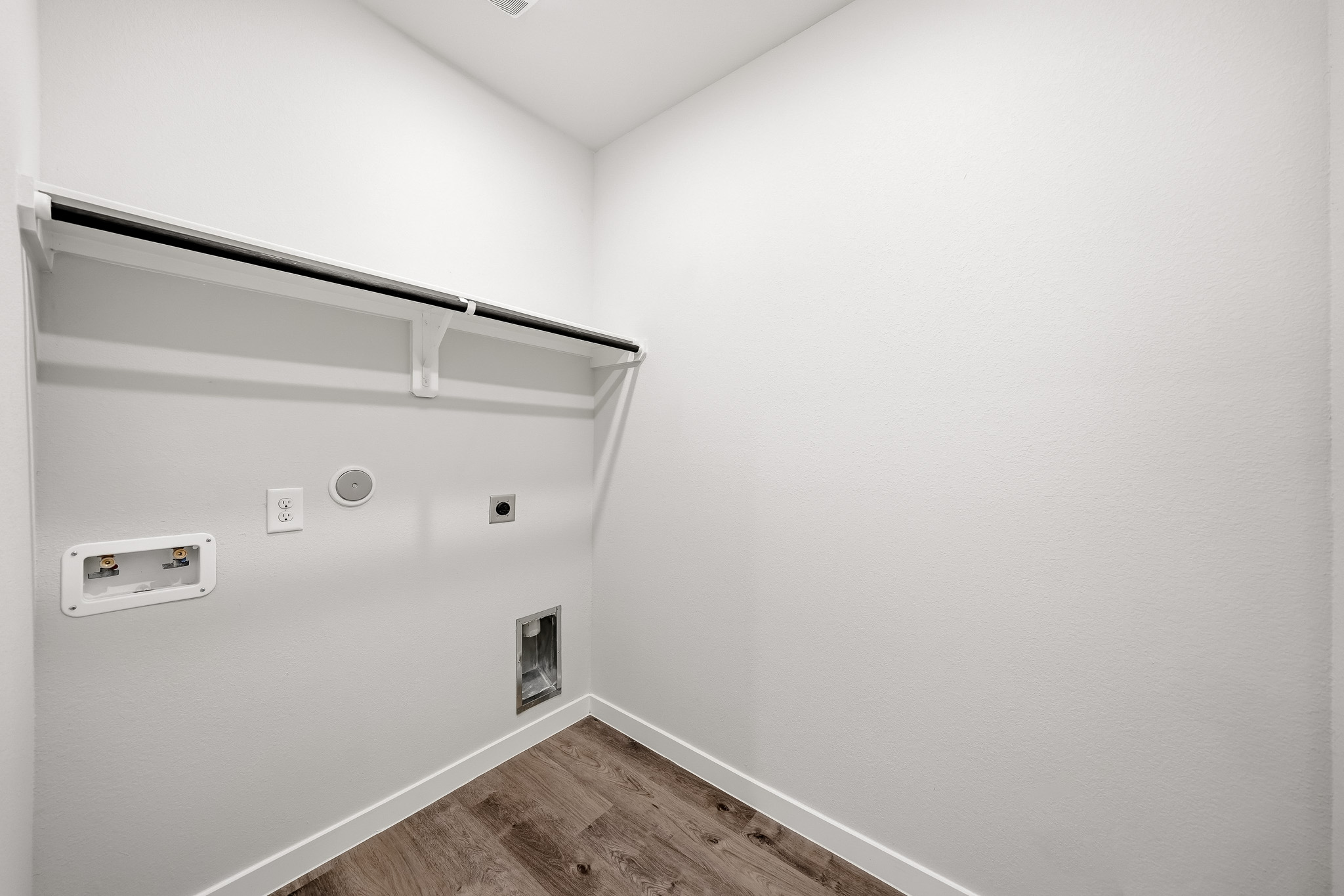 A white wall with a wood floor.