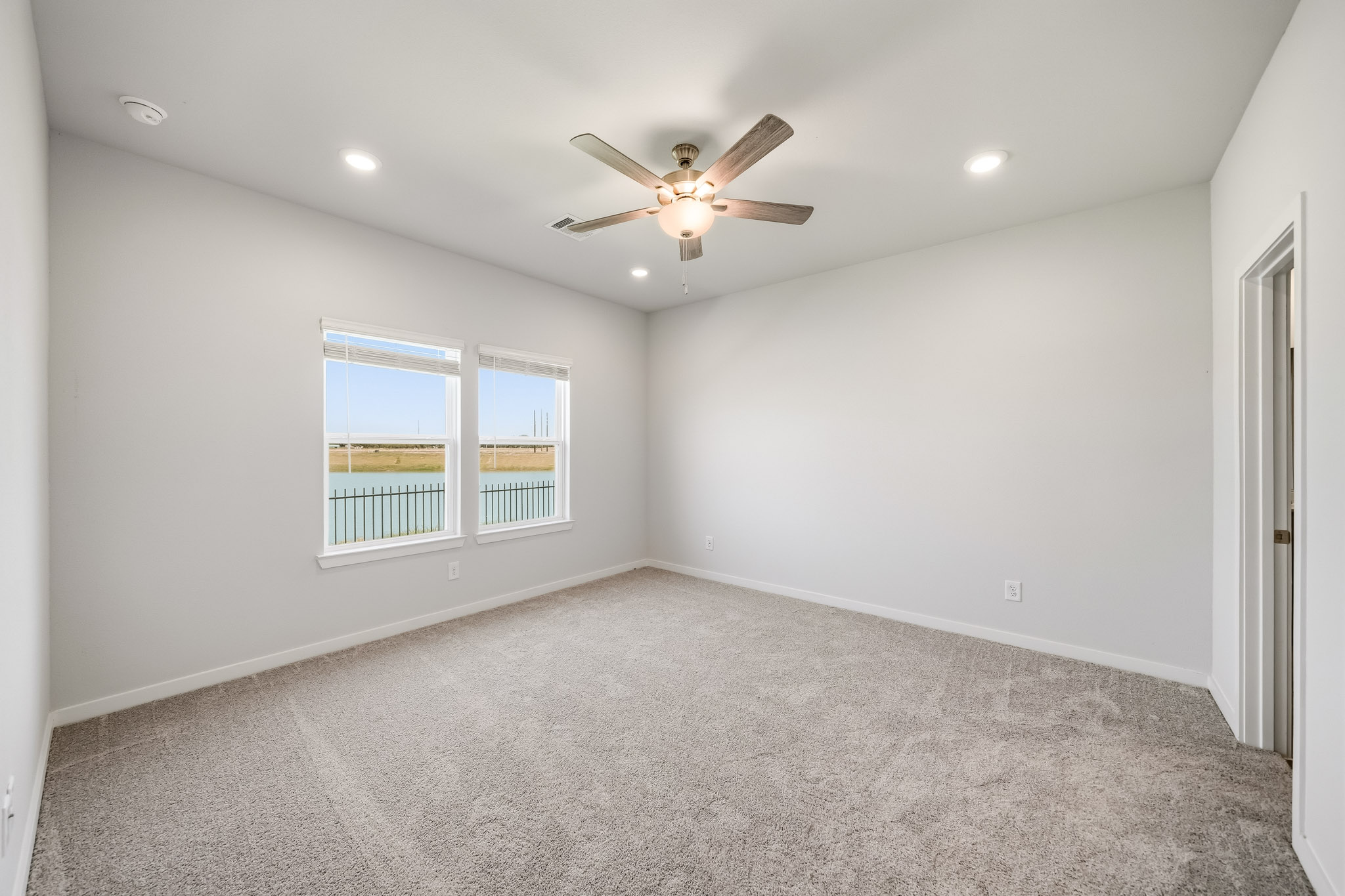 A room with a ceiling fan and a window.
