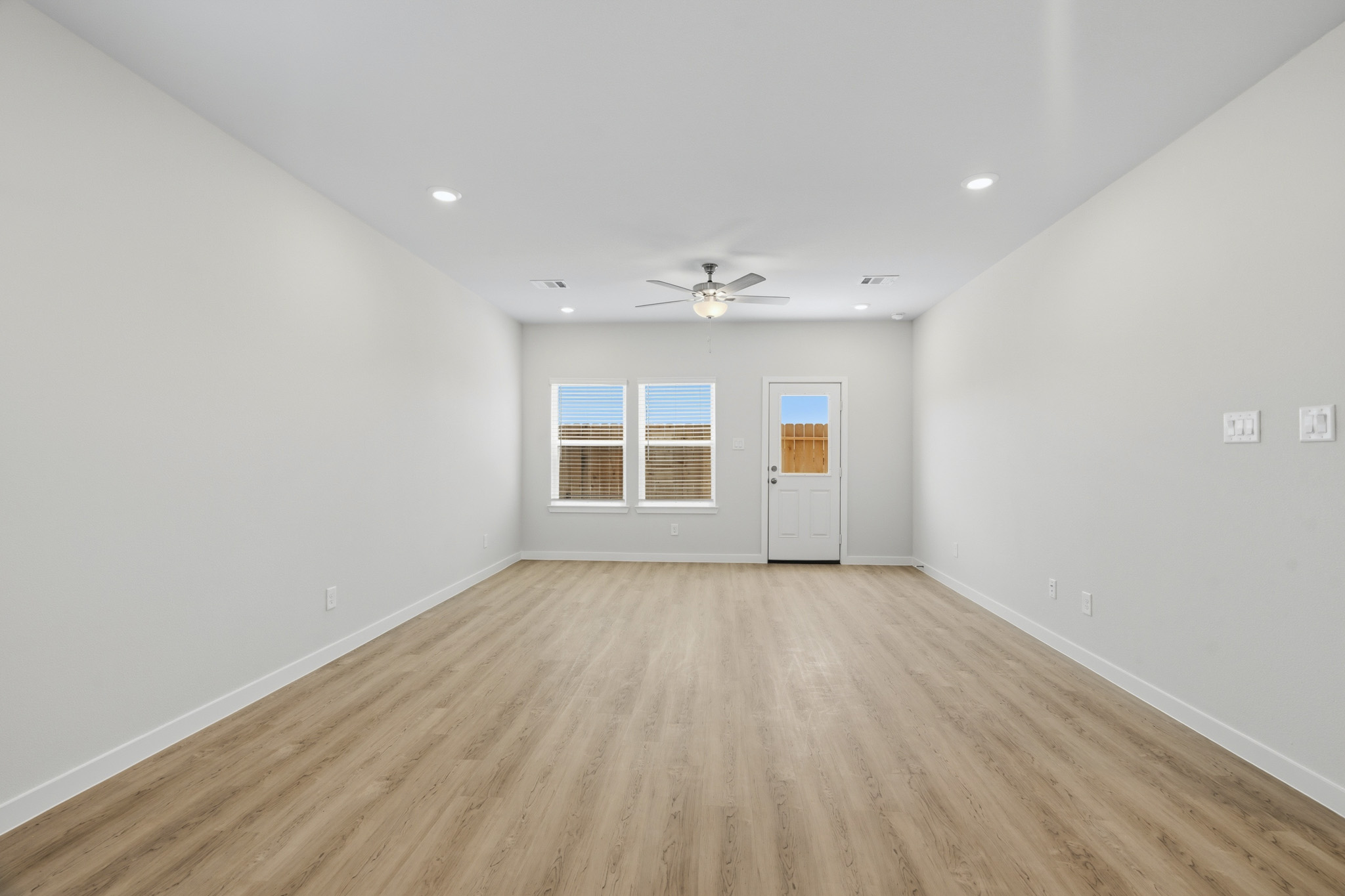 A room with a wood floor and a ceiling fan.
