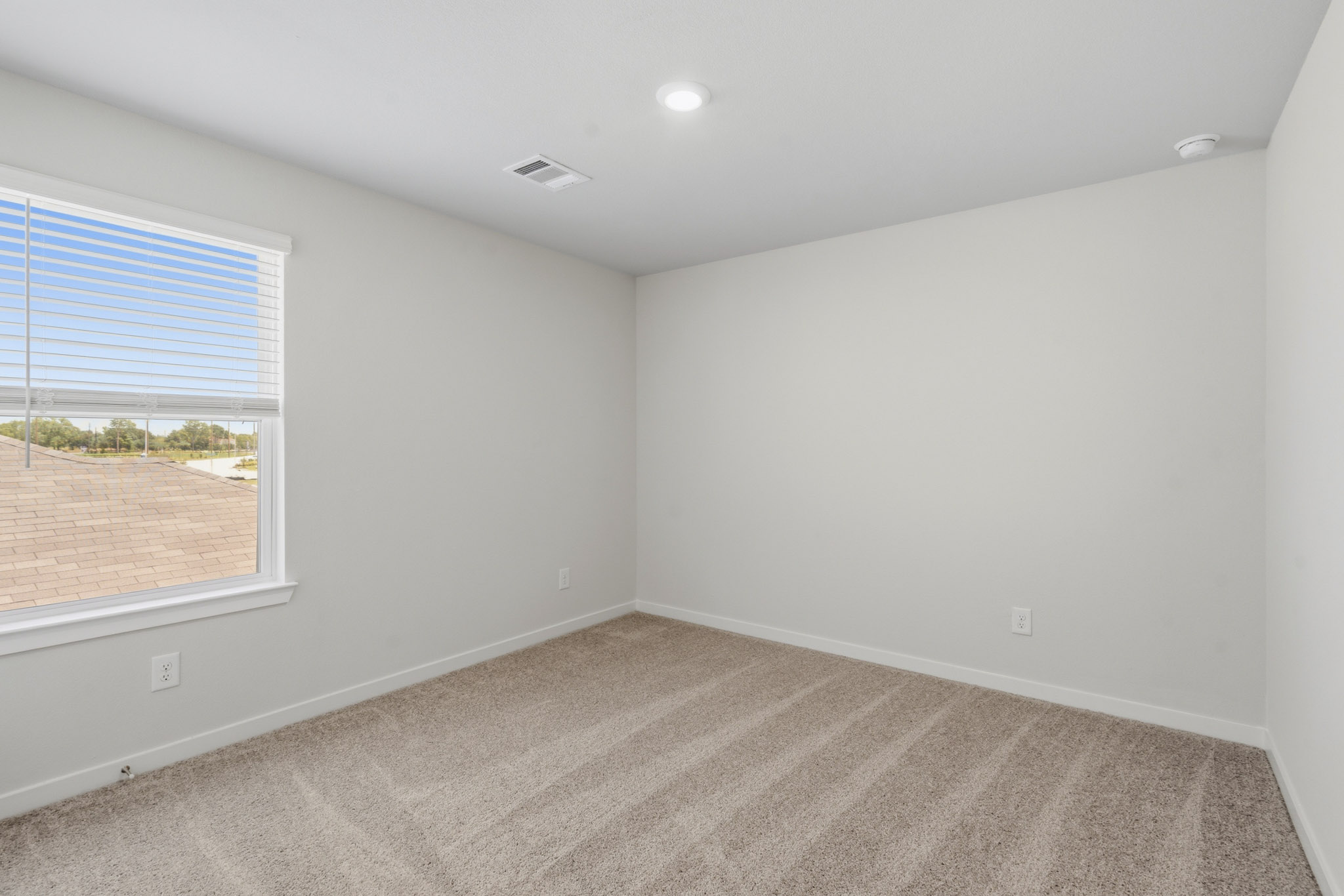 A room with a carpet and a window.