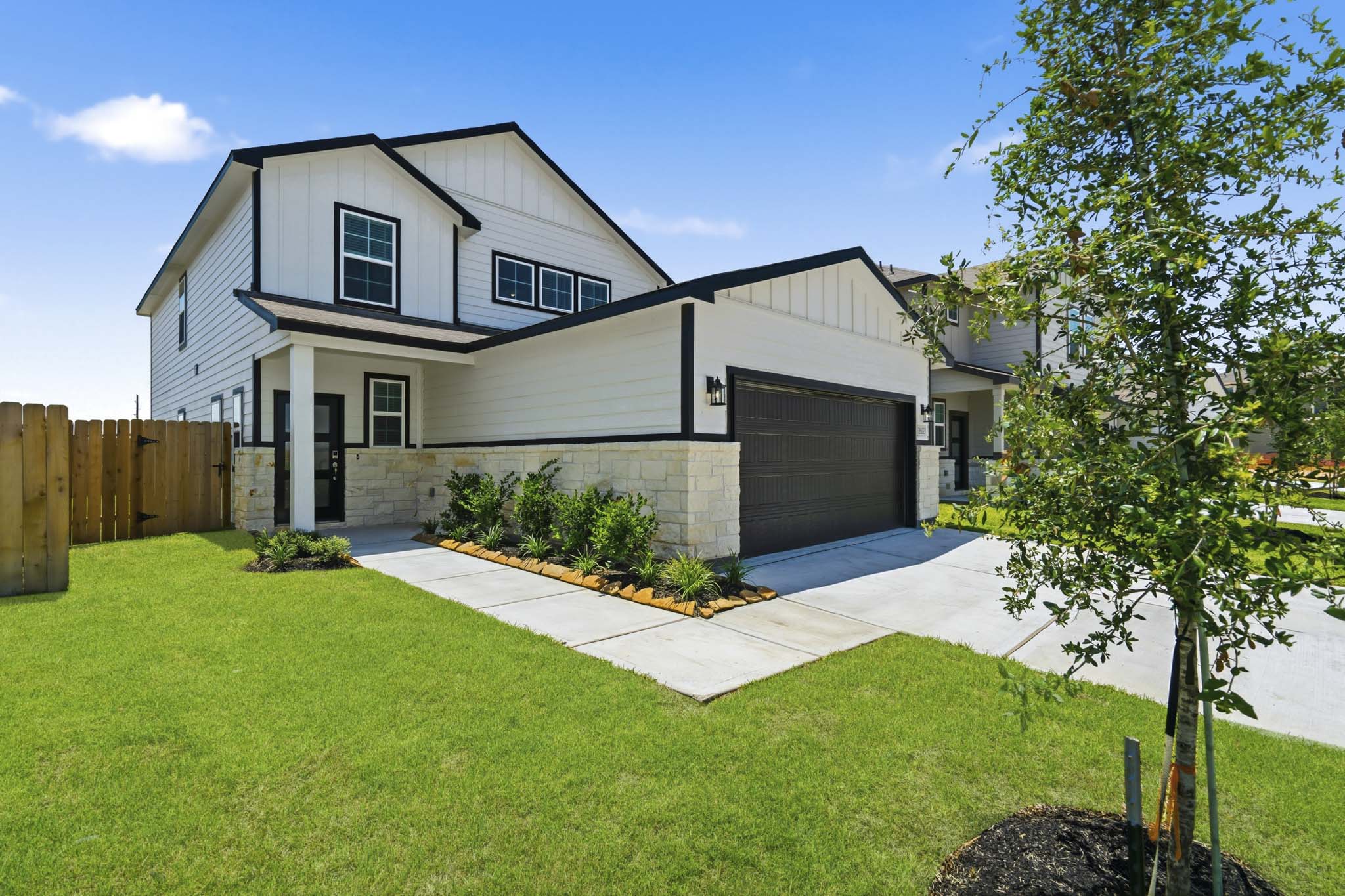 A house with a fence and a tree in the front.