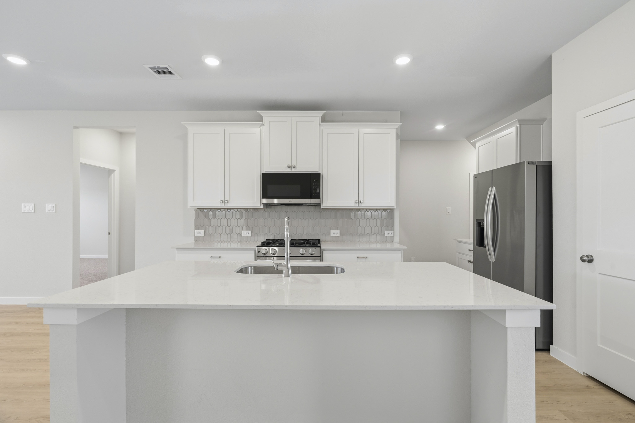 A kitchen with white cabinets.