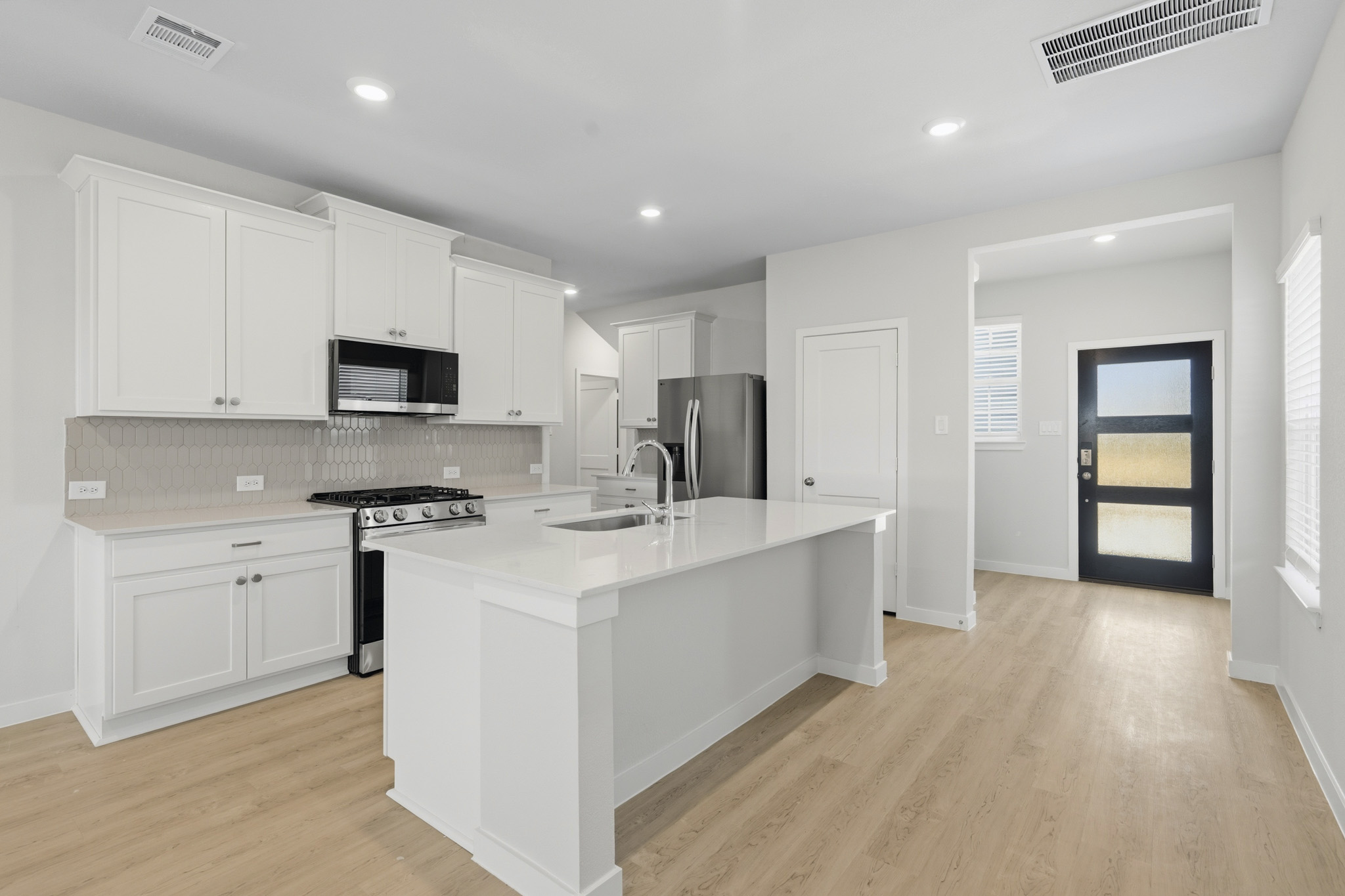 A kitchen with white cabinets.