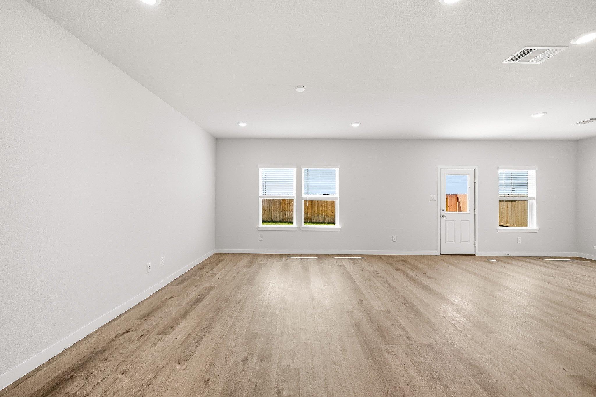 A room with a wood floor and windows.