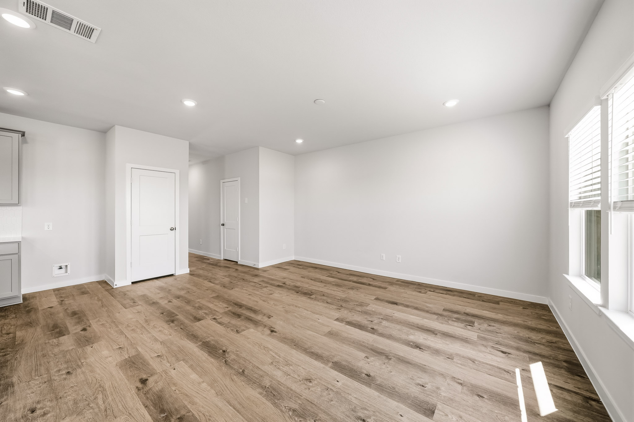 A room with a wood floor and white walls.