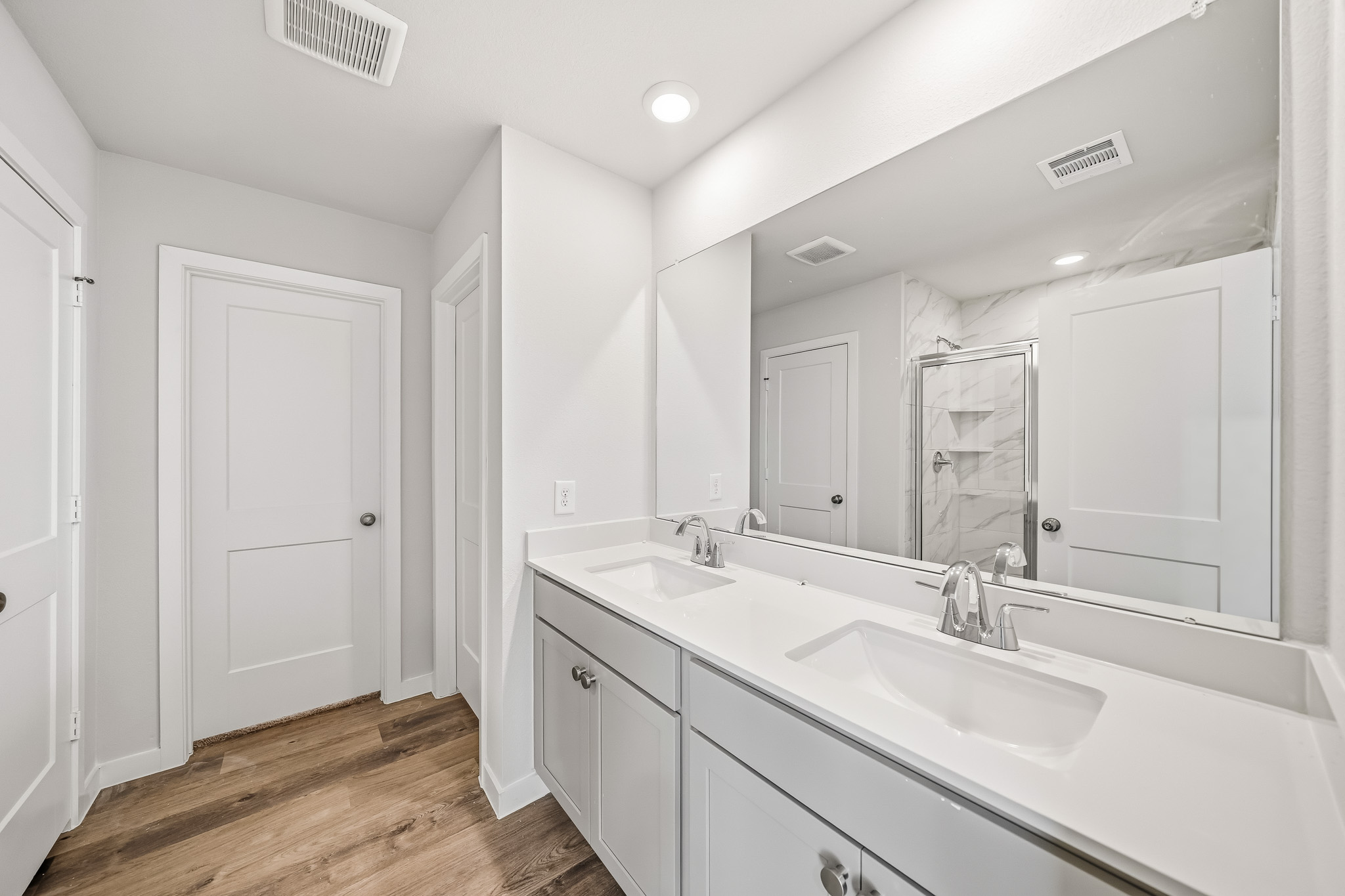 A bathroom with white cabinets.