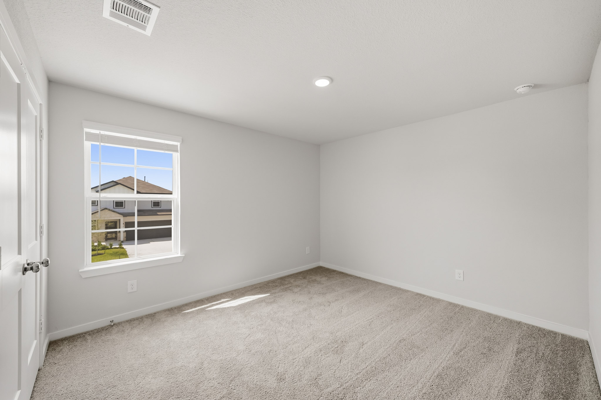 A room with a window and a carpet.
