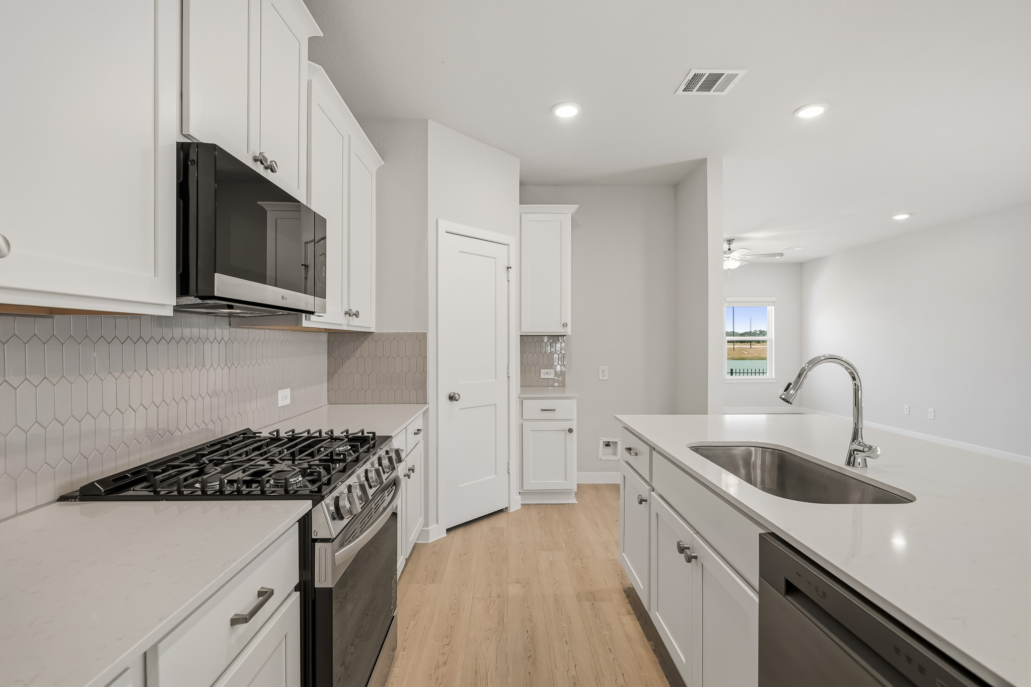 A kitchen with white cabinets.