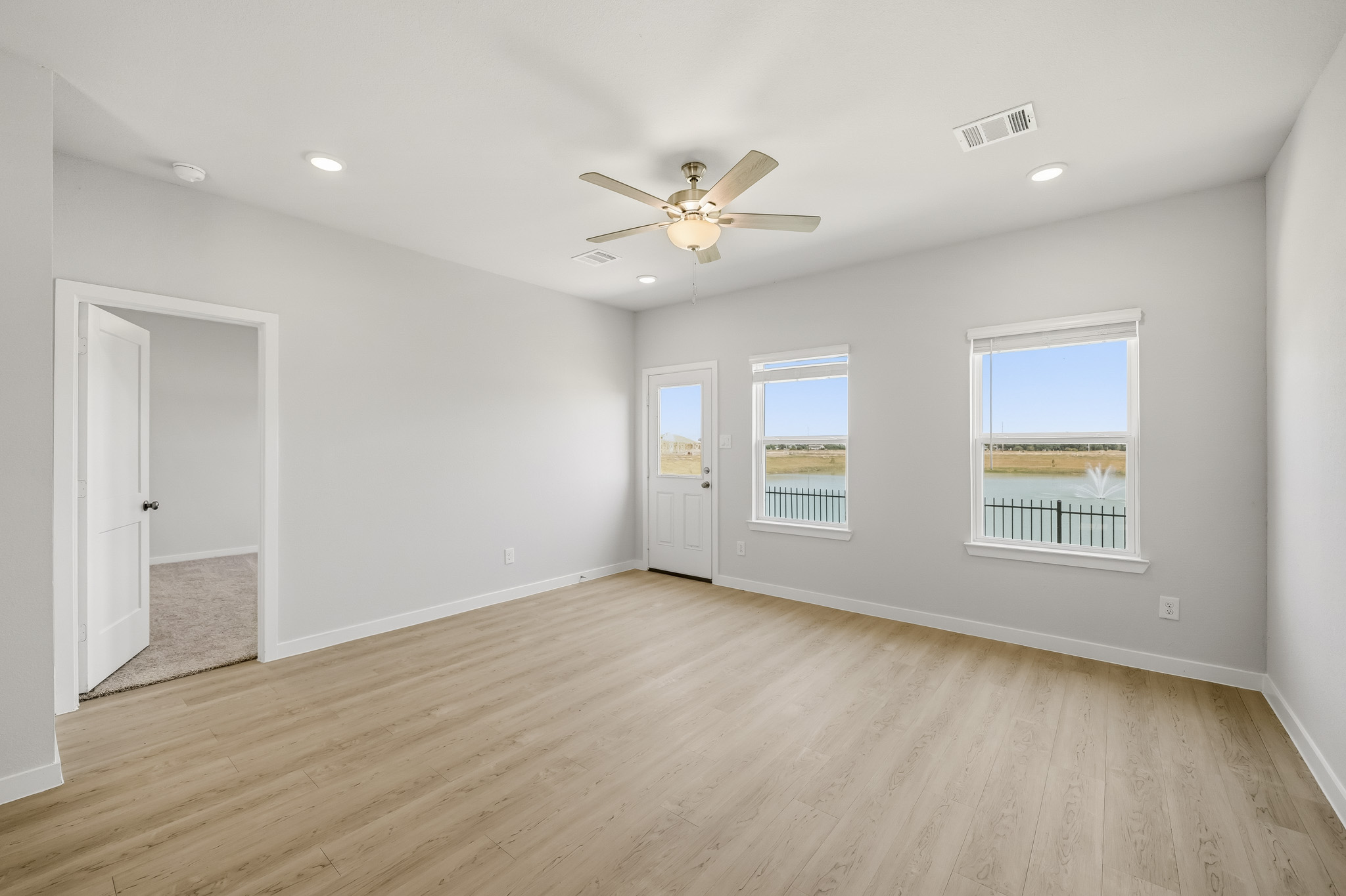 A room with a wood floor and a ceiling fan.